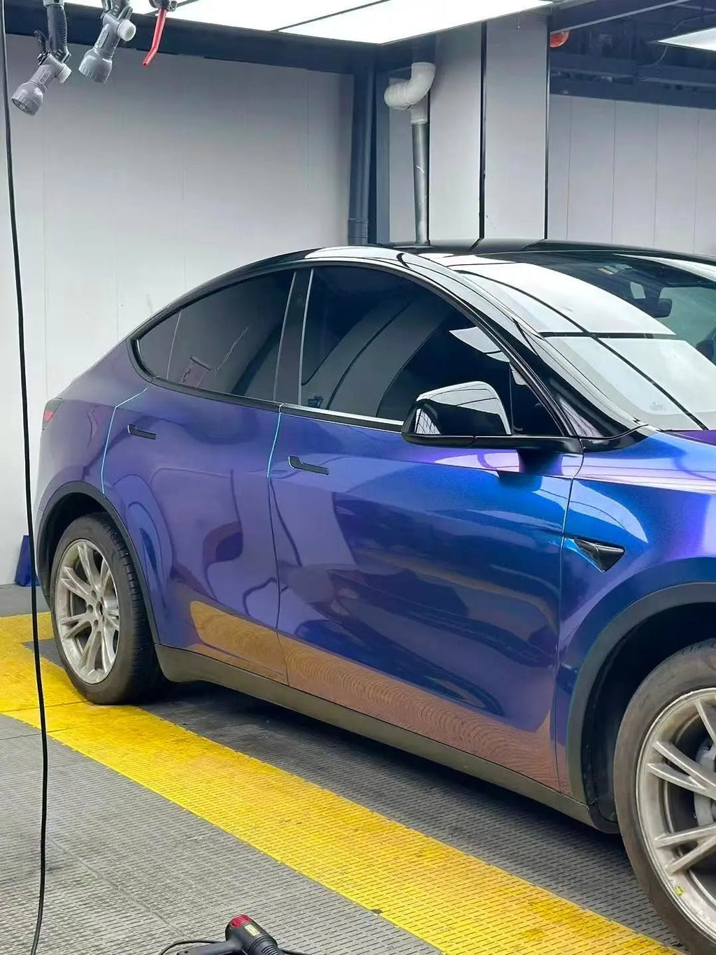 Close-up of Diamond Purple Blue film on Tesla Model Y front-right bumper - Kaleido