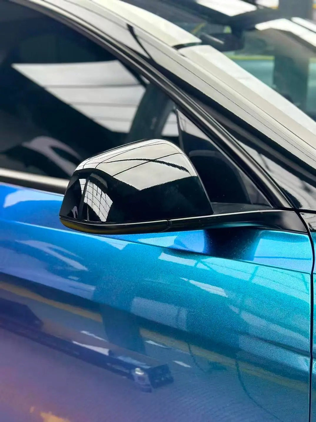 Macro detail of Diamond Purple Blue color shift vinyl on Tesla Model Y side mirror - Kaleido
