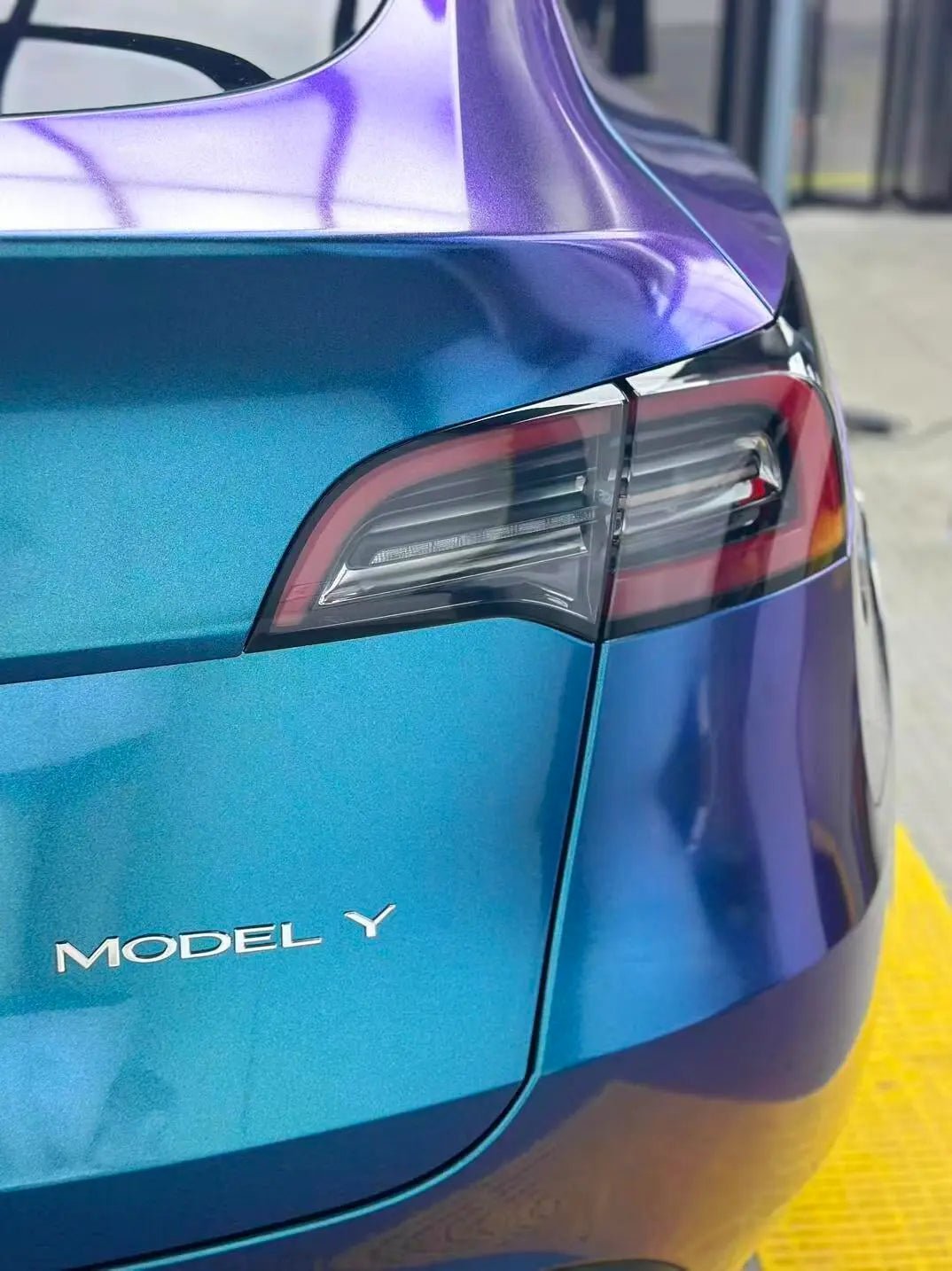 Detailed view of Diamond Purple Blue vinyl on Tesla Model Y rear-right corner - Kaleido