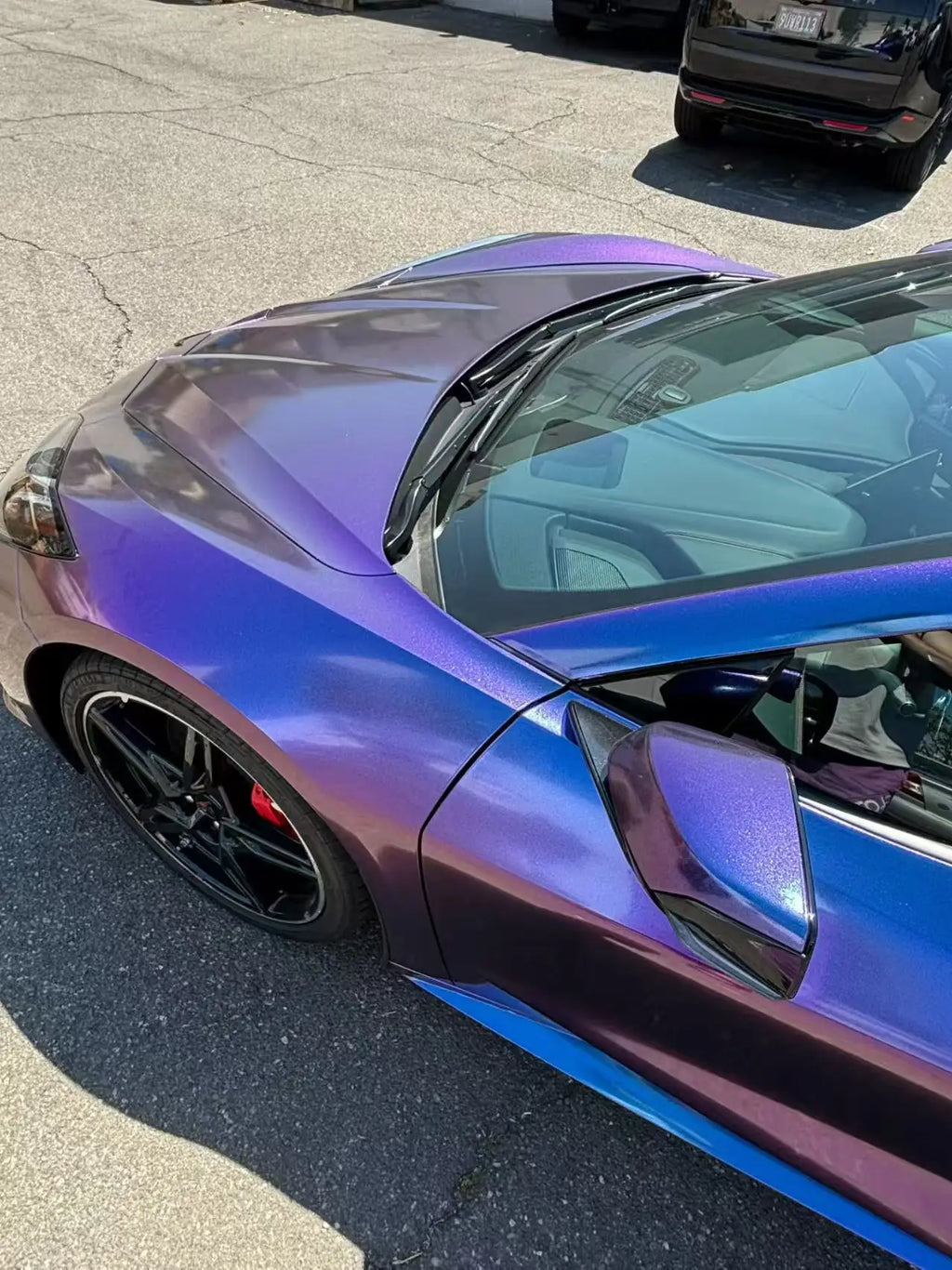 Close-up detail of Diamond Purple Red color shift wrap on Corvette C8 side mirror and fender - Kaleido