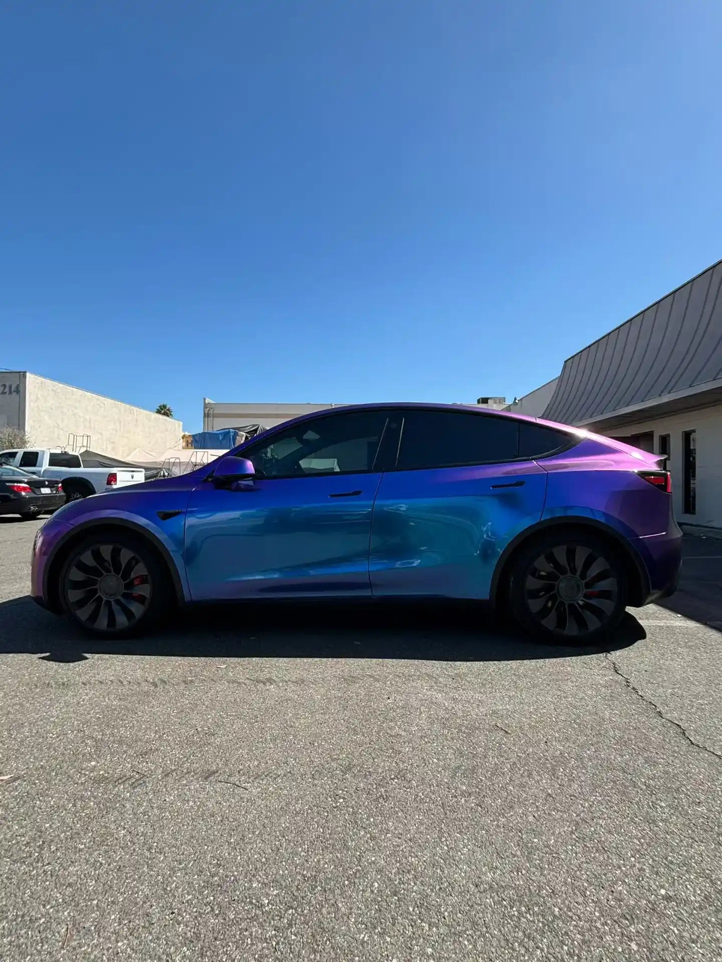 Diamond Purple Red color shift vinyl on Tesla Model Y - left side profile of the SUV - Kaleido