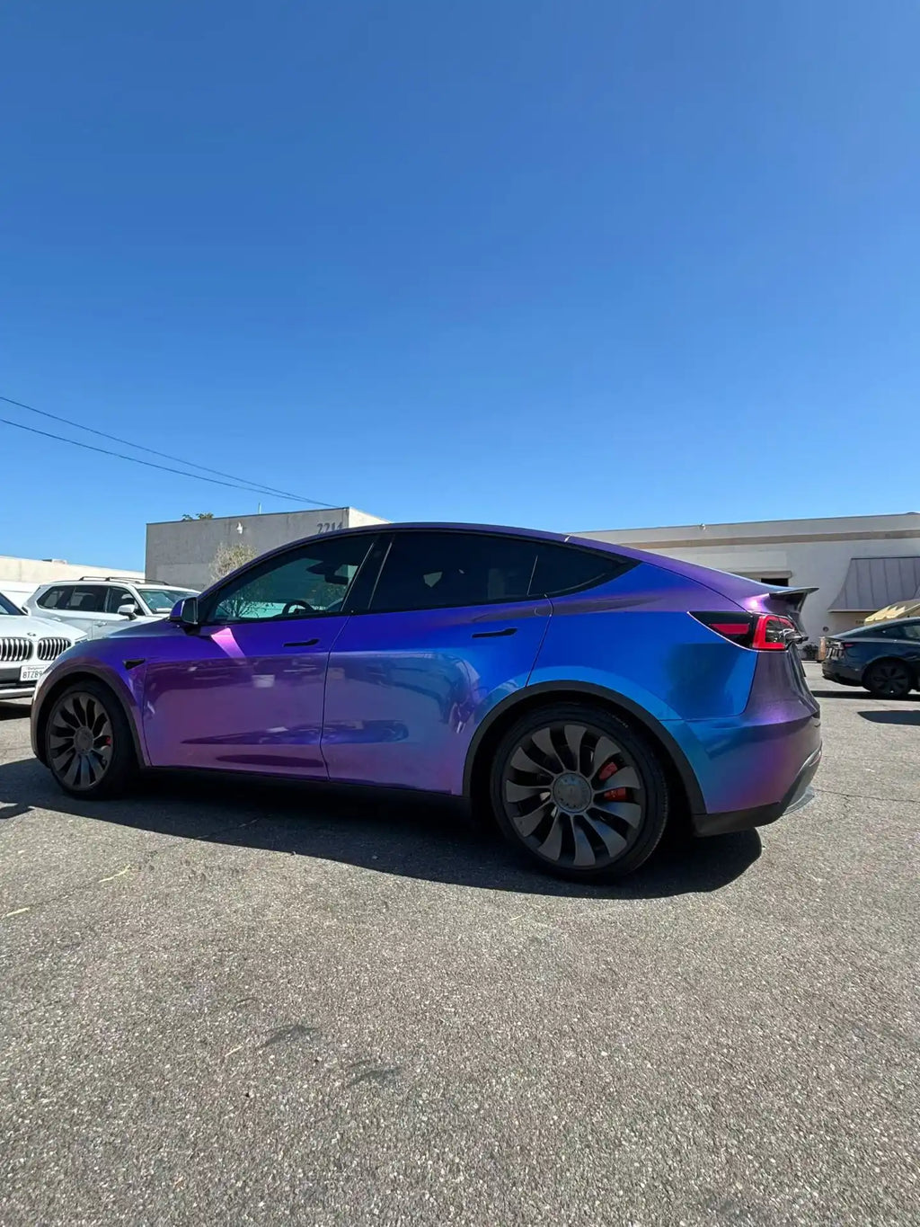 Tesla Model Y in Diamond Purple Red color shift wrap - rear-left view showing purple to red transition - Kaleido