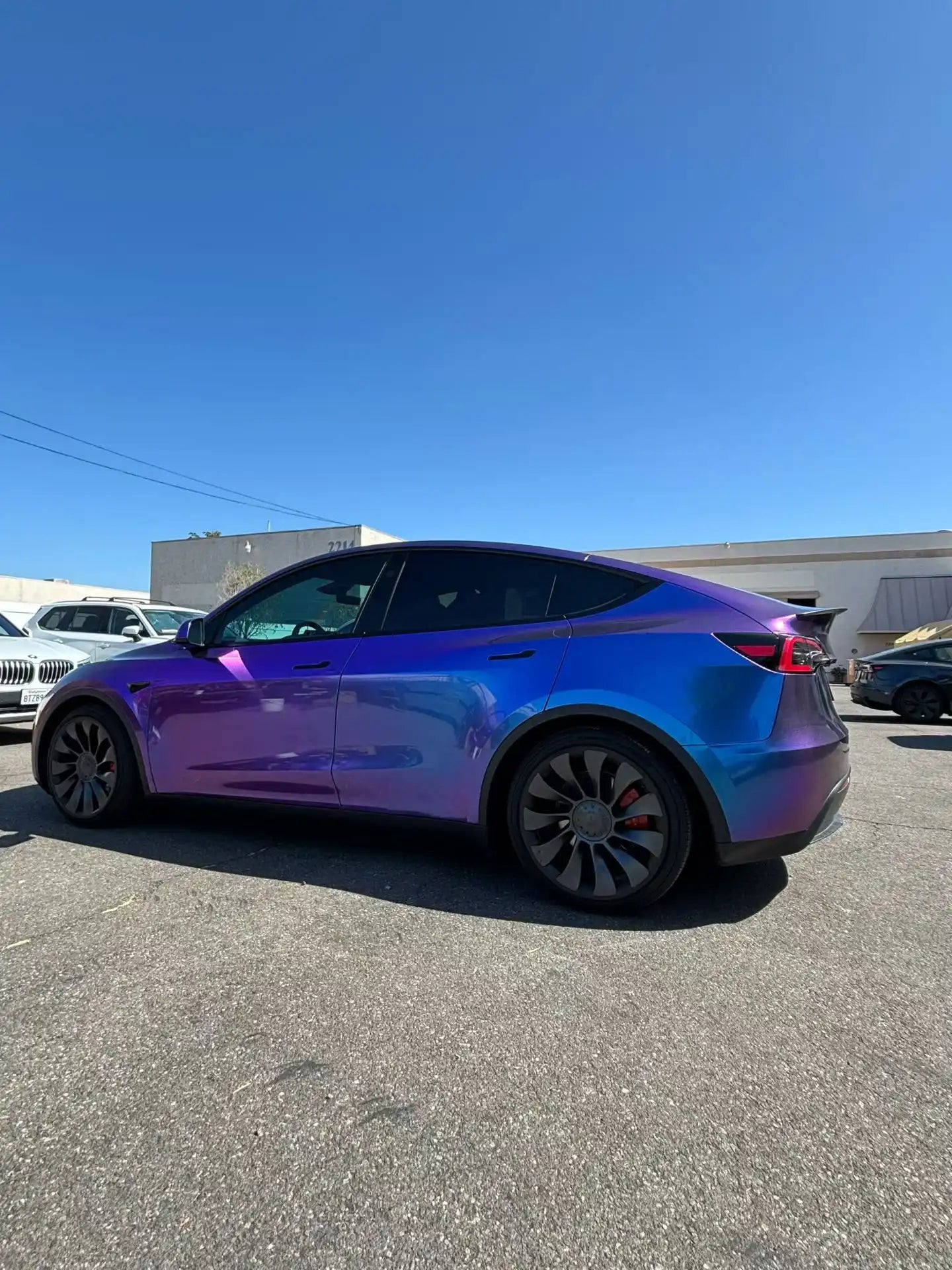 Tesla Model Y in Diamond Purple Red color shift wrap - rear-left view showing purple to red transition - Kaleido