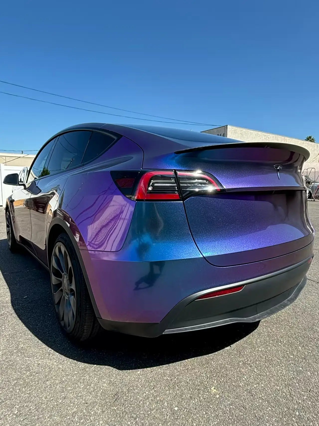 Wide rear-left view of Tesla Model Y in Diamond Purple Red color shift wrap - Kaleido