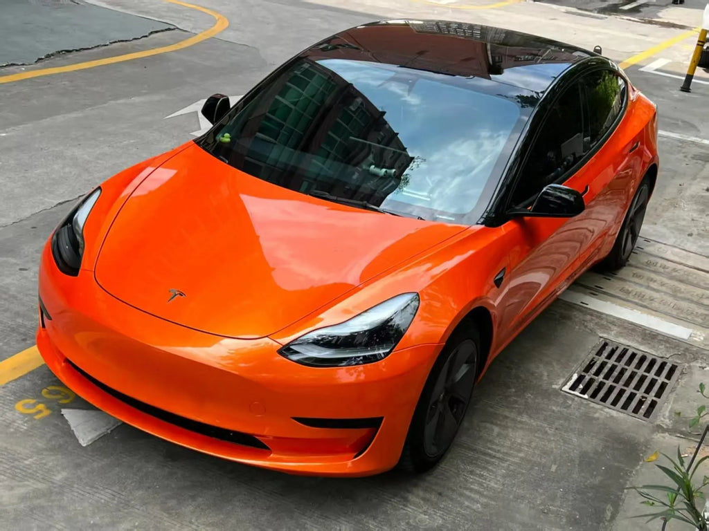 Tesla Model 3 in Neon Gold Orange - front-left view showing sedan styling - Kaleido