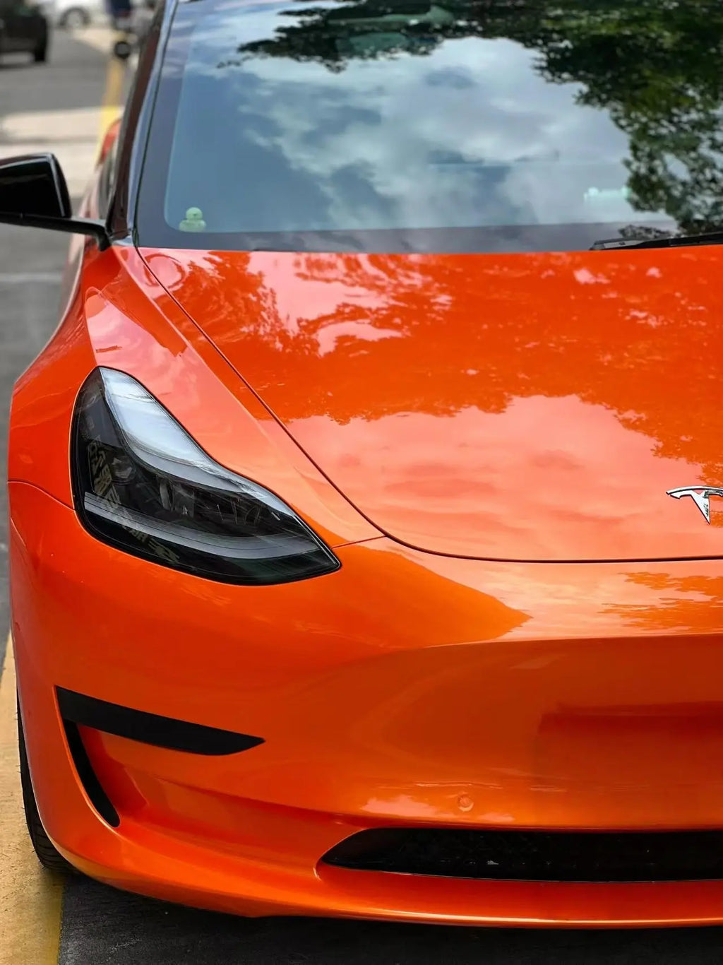 Neon Gold Orange color shift wrap on Tesla Model 3 front-right corner - showcasing color transformation - Kaleido