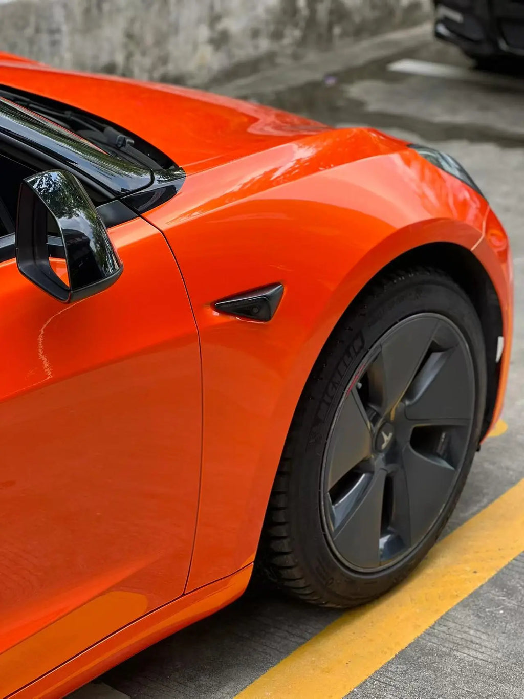 Close-up of Neon Gold Orange film on Tesla Model 3 front-right - precise installation on bumper and headlight - Kaleido