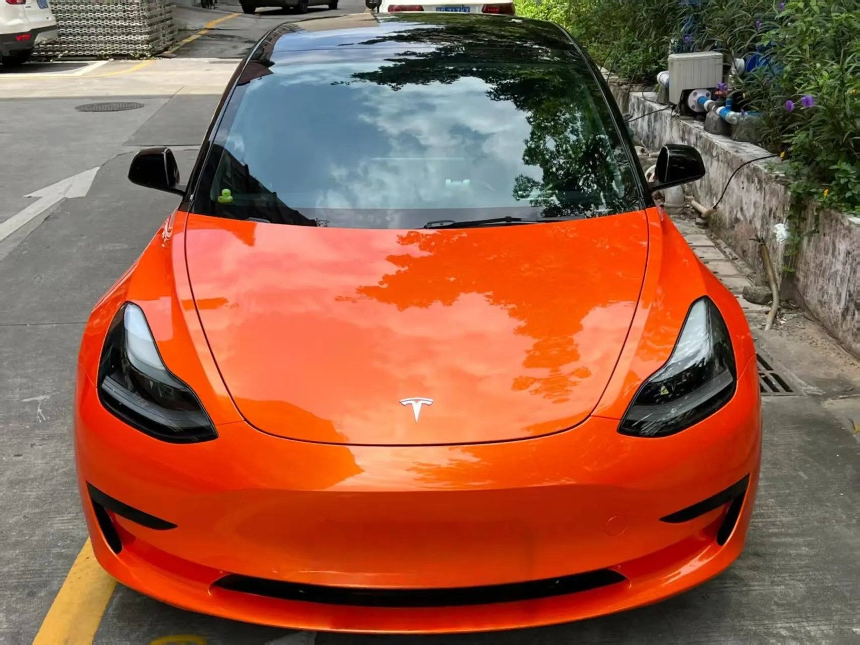 Front view of Tesla Model 3 in Neon Gold Orange color shift wrap - sleek electric car design - Kaleido