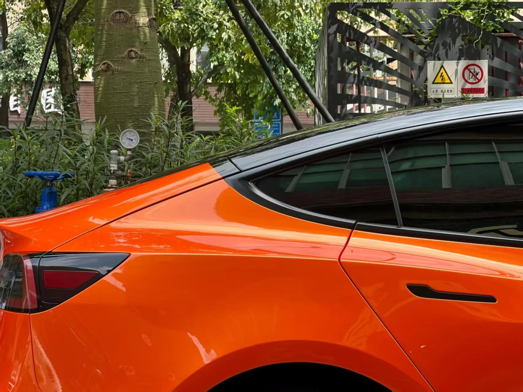 Neon Gold Orange wrap on Tesla Model 3 rear fender - color shift detail on body panel - Kaleido