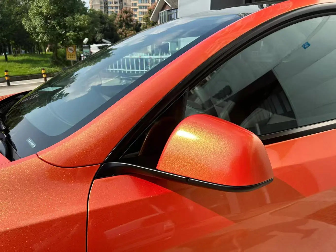 Detailed view of Neon Gold Orange vinyl on Tesla Model Y side mirror - precise installation - Kaleido
