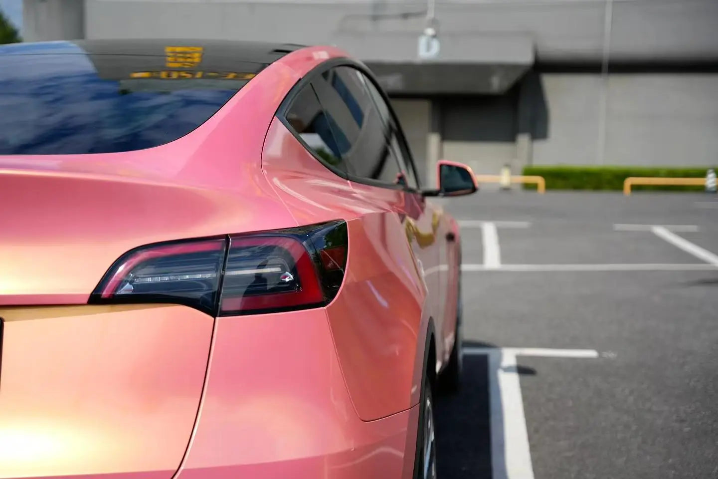 Rear-right corner view of Neon Gold Pink wrapped Tesla Model Y - Kaleido