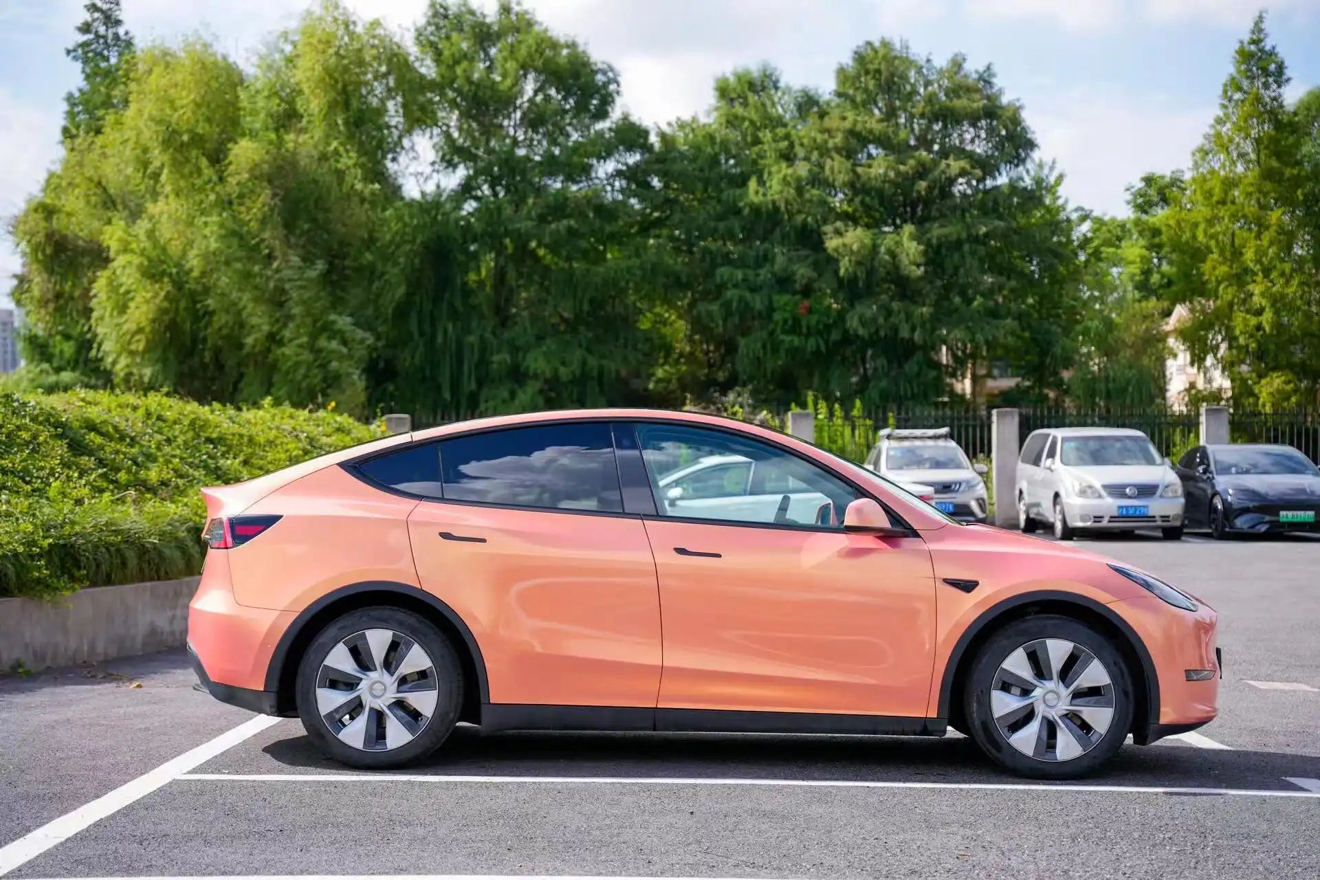 Outdoor side view of Neon Gold Pink wrapped Tesla Model Y - natural lighting showcase - Kaleido