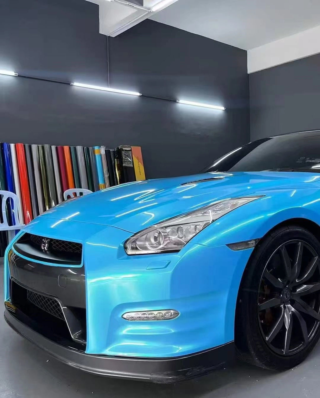 Detailed view of Neon Sky Blue wrap on Nissan GT-R left front - highlighting color shift effect - Kaleido