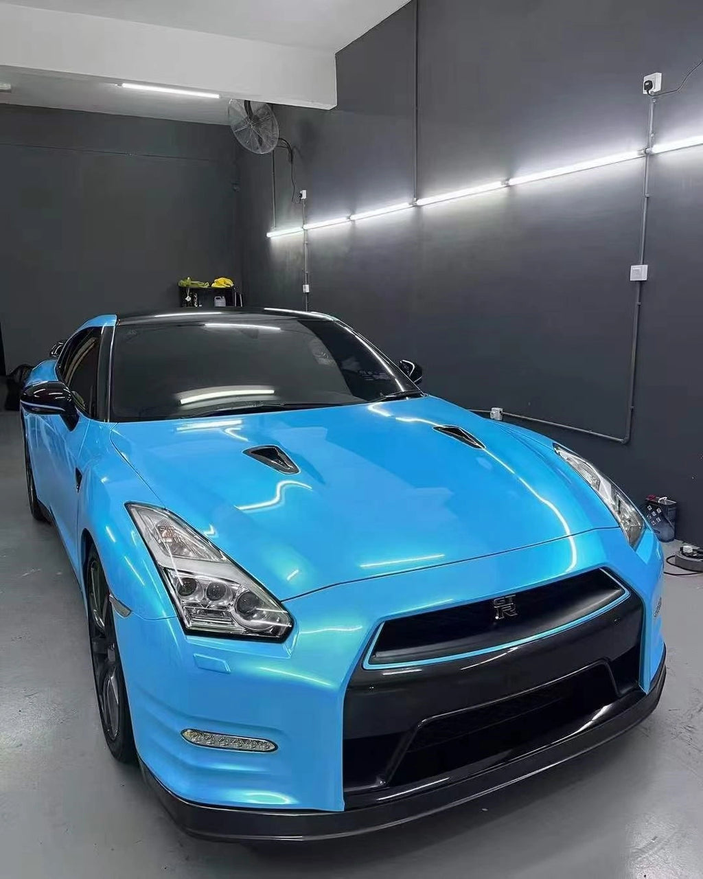 Neon Sky Blue color shift vinyl on Nissan GT-R R35 front-right - showcasing iconic supercar lines - Kaleido