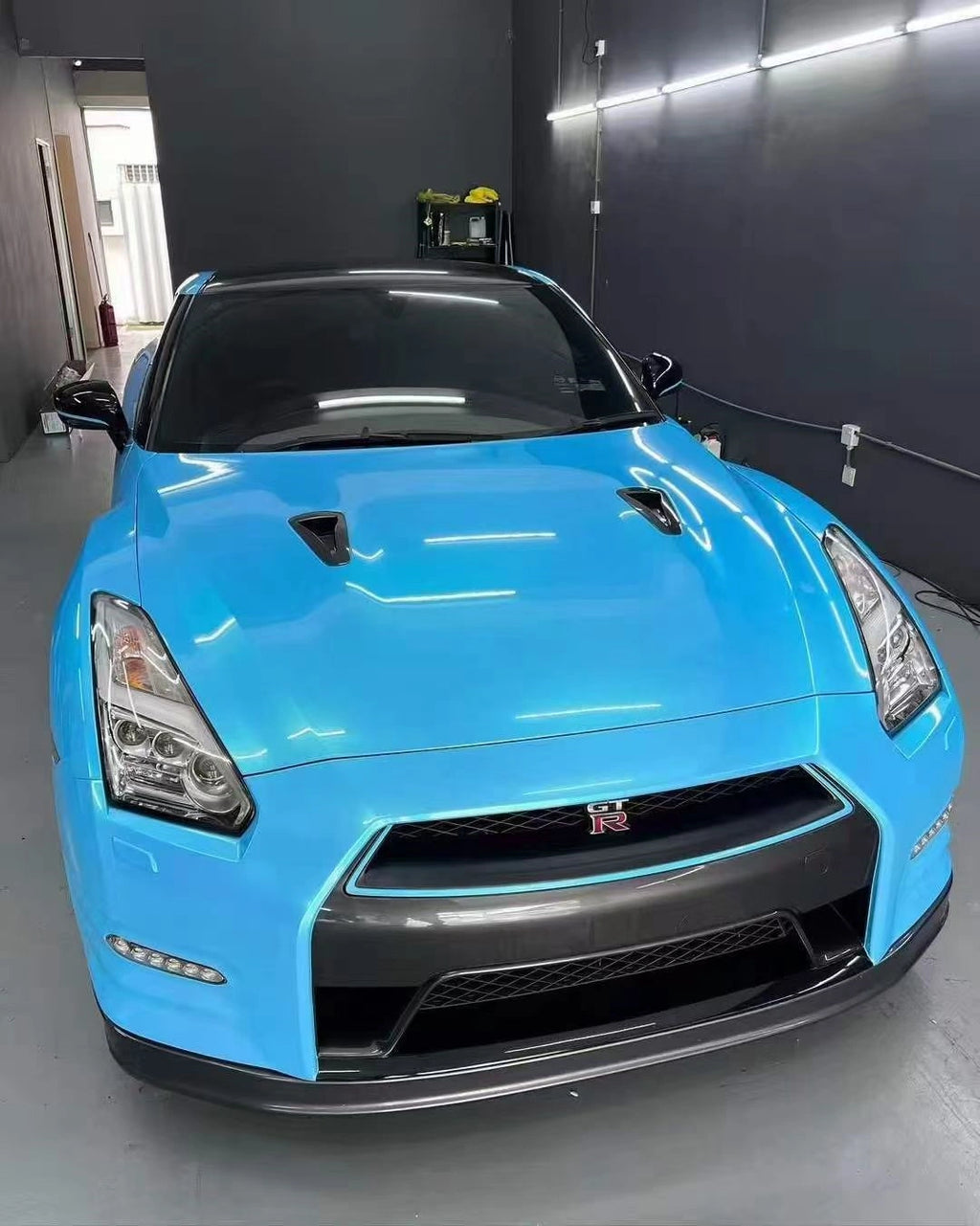Nissan GT-R R35 in Neon Sky Blue color shift wrap - front view showing blue to coral transition - Kaleido