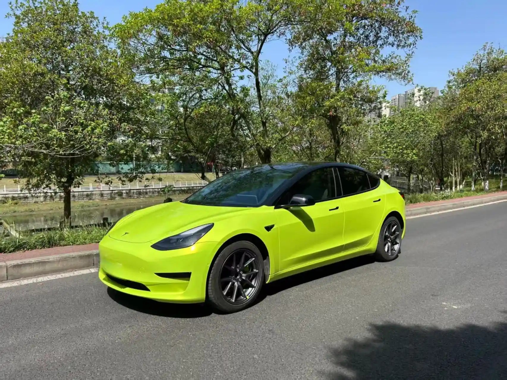Tesla Model 3 in Neon Yellow - front-left view showcasing electric sedan lines - Kaleido