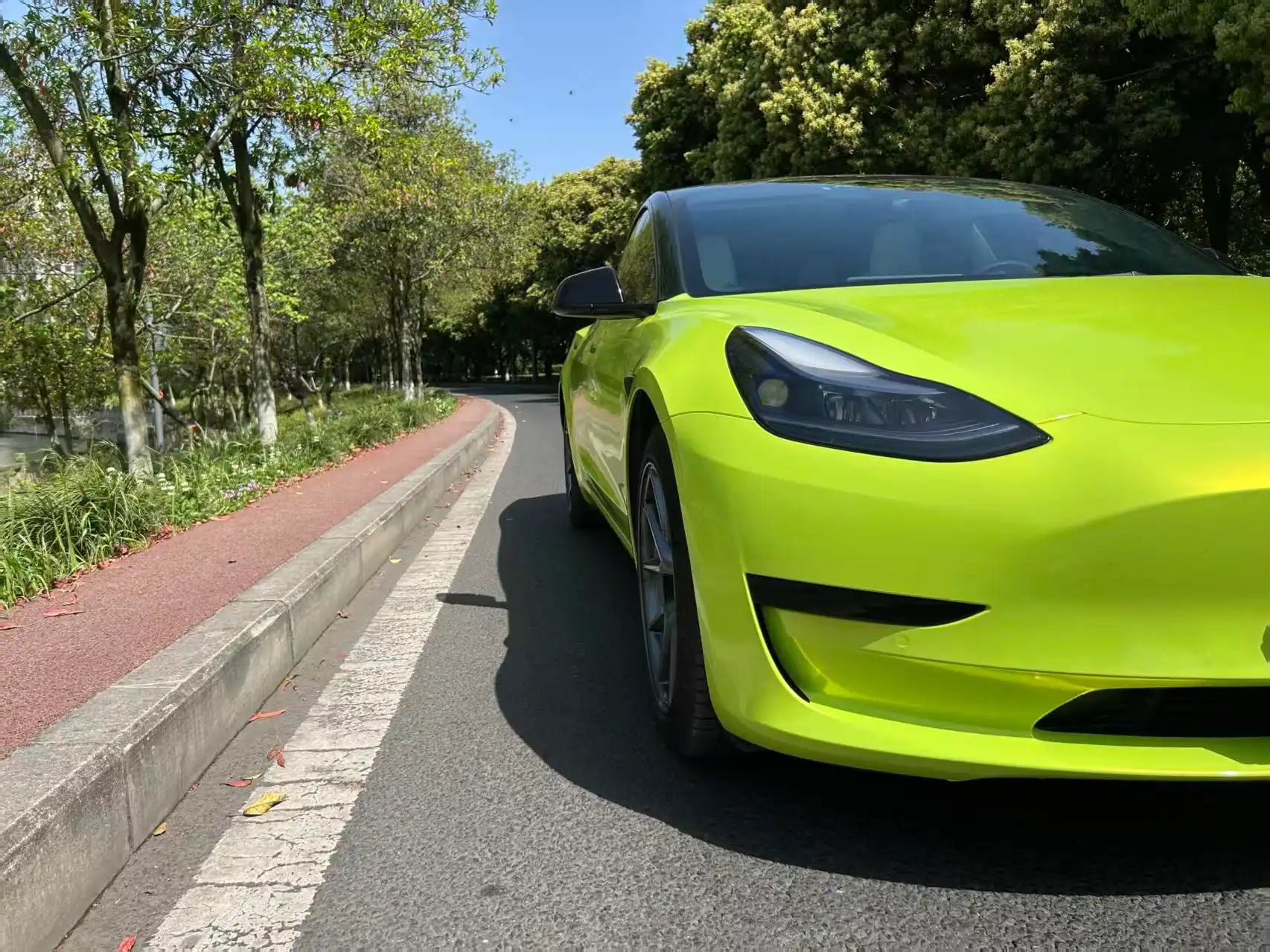 Front-right corner view of Neon Yellow wrapped Tesla Model 3 - Kaleido