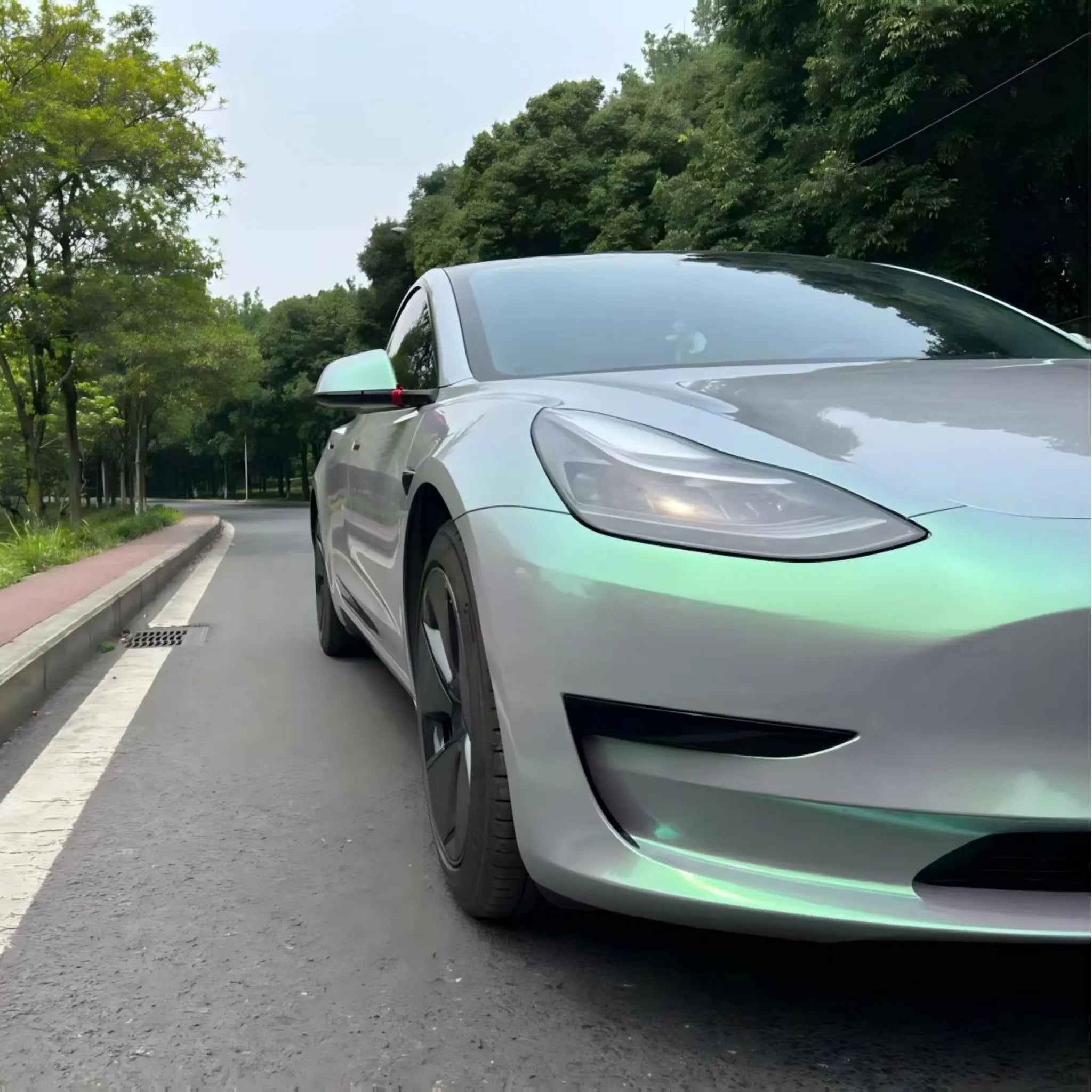 Close-up shot of Phantom Moss color shift wrap on Model 3 front-right - Kaleido