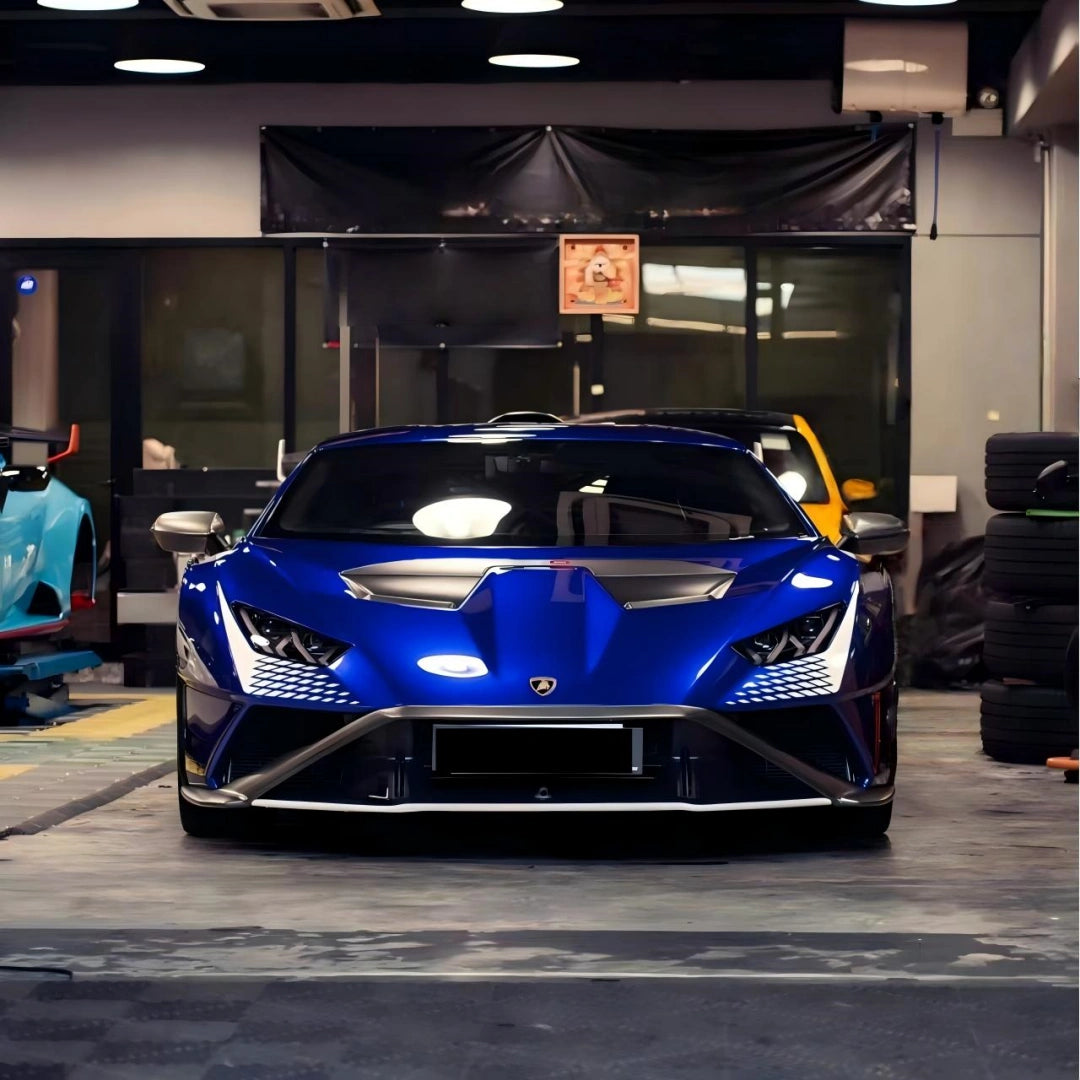 Deep Blueberry Metallic vinyl wrap on the front of a Lamborghini Huracán STO, showcasing the sharp headlights and aggressive bumper[citation:1] - Kaleido