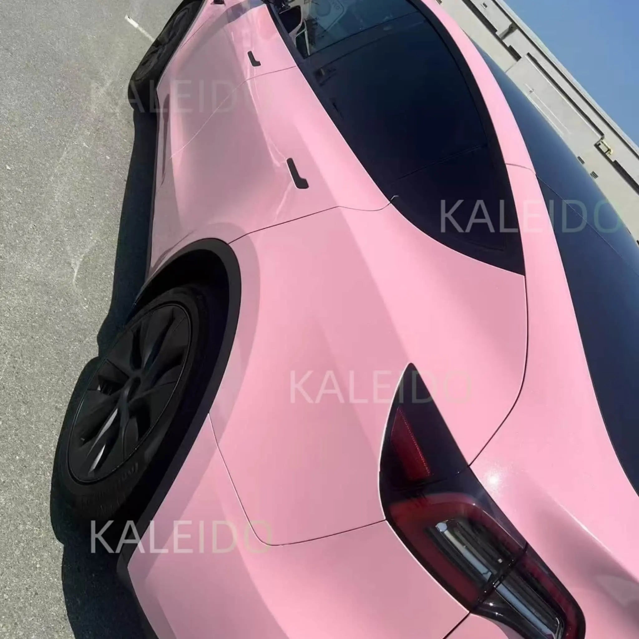 Close-up detail of Diamond Iridescent Rouge Pink film on Tesla Model Y rear-left panel - Kaleido