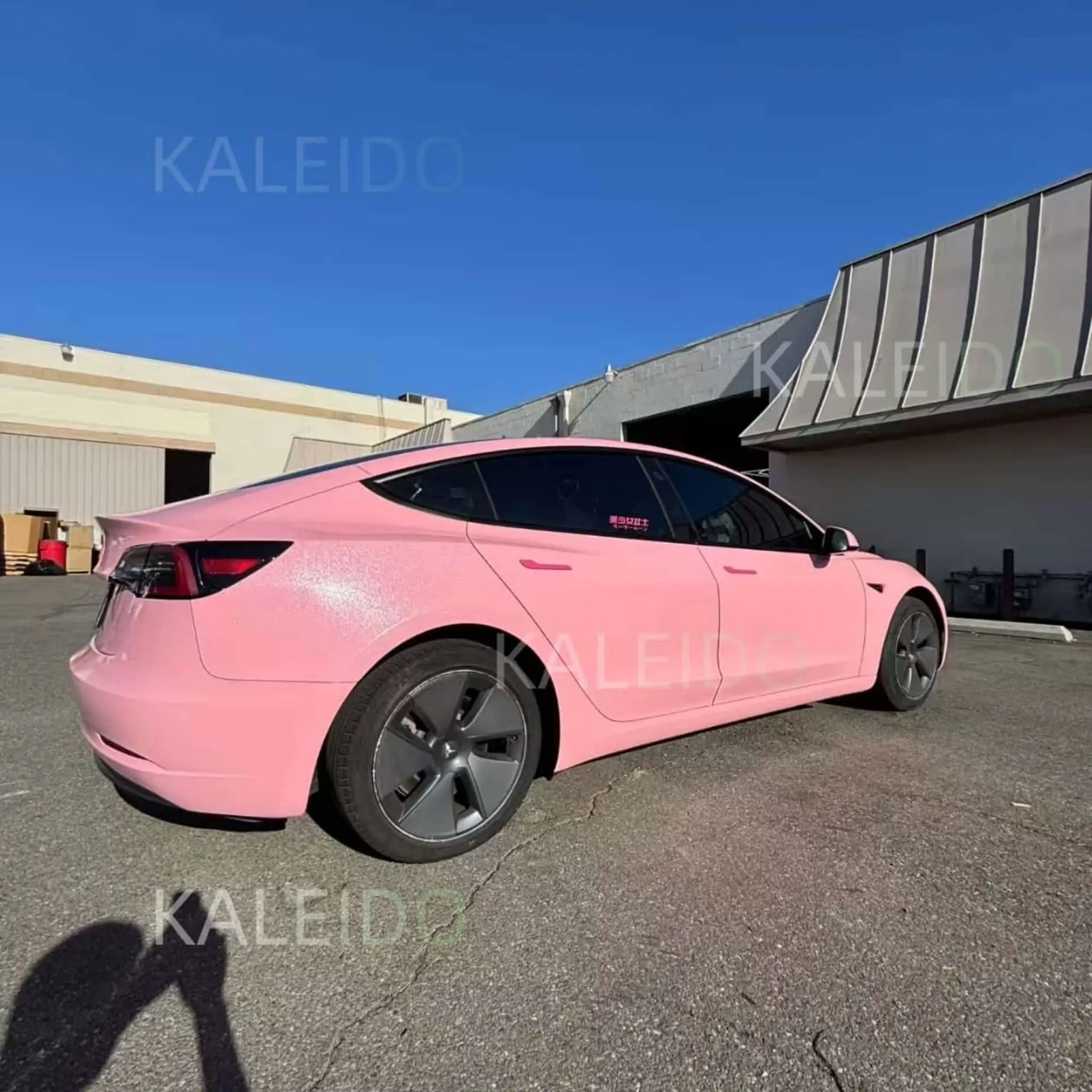 Tesla Model Y in Diamond Iridescent Rouge Pink - rear-right angle showing iridescent shimmer - Kaleido