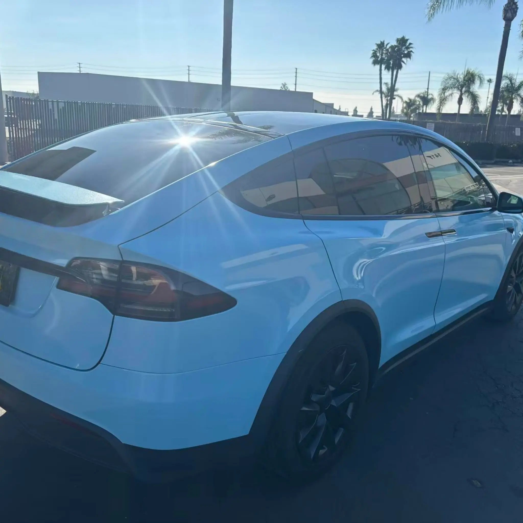 Tesla Model X with Diamond Iridescent Sea Mist Blue film - rear-right angle showing iridescent ocean shimmer - Kaleido