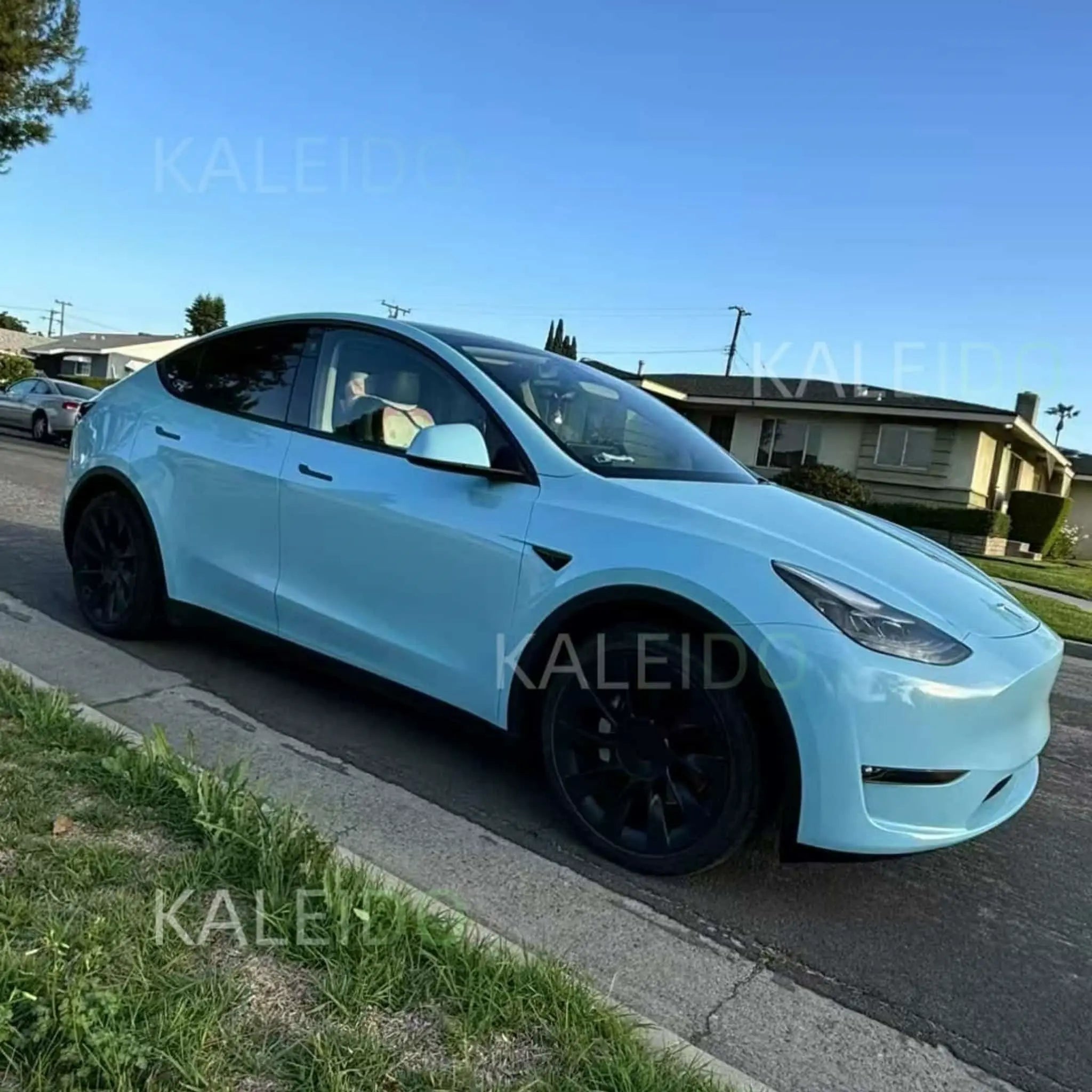 Diamond Iridescent Sea Mist Blue wrap on Tesla Model Y - front-right angle with ocean shimmer effect - Kaleido