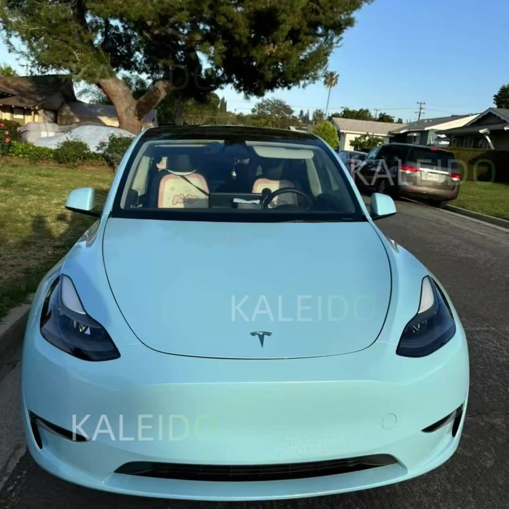 Tesla Model Y in Diamond Iridescent Sea Mist Blue vinyl wrap - front view showing soft pearlescent blue finish - Kaleido
