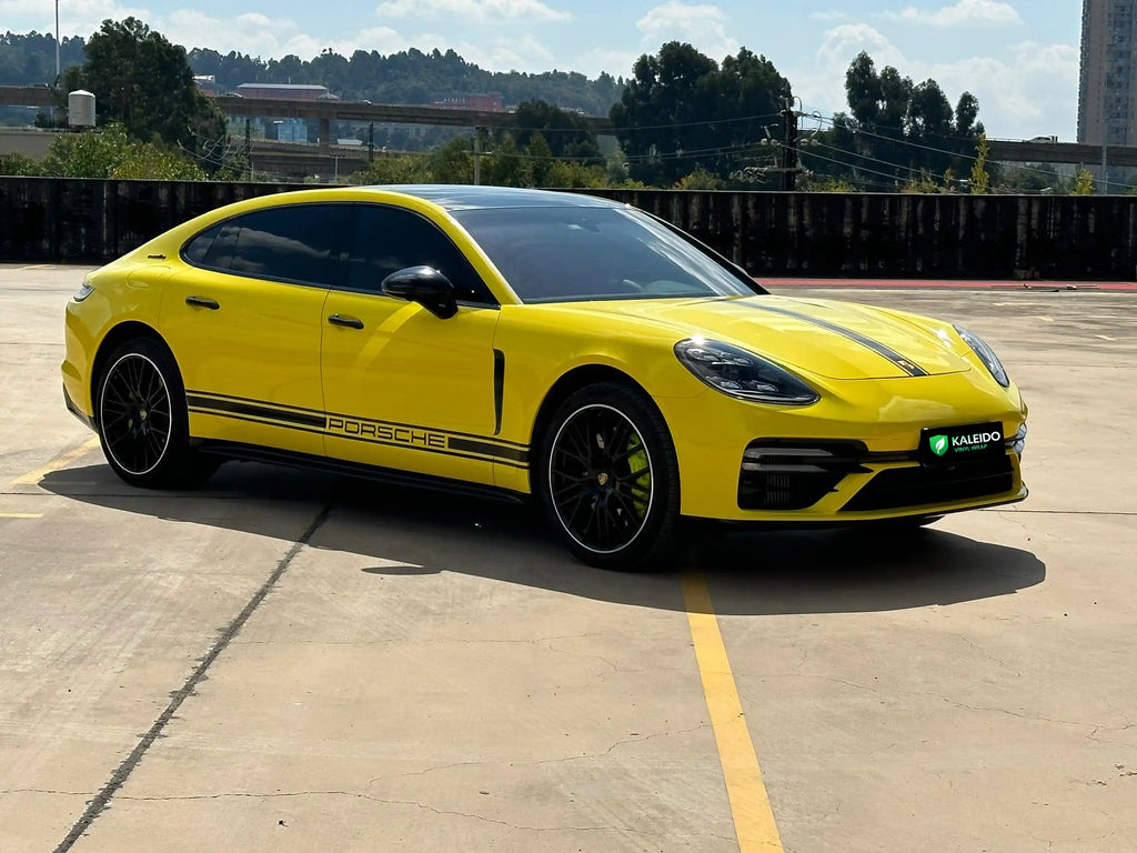 Wide front-right view of a Gloss Corn Yellow wrapped modified Porsche Panamera - Kaleido