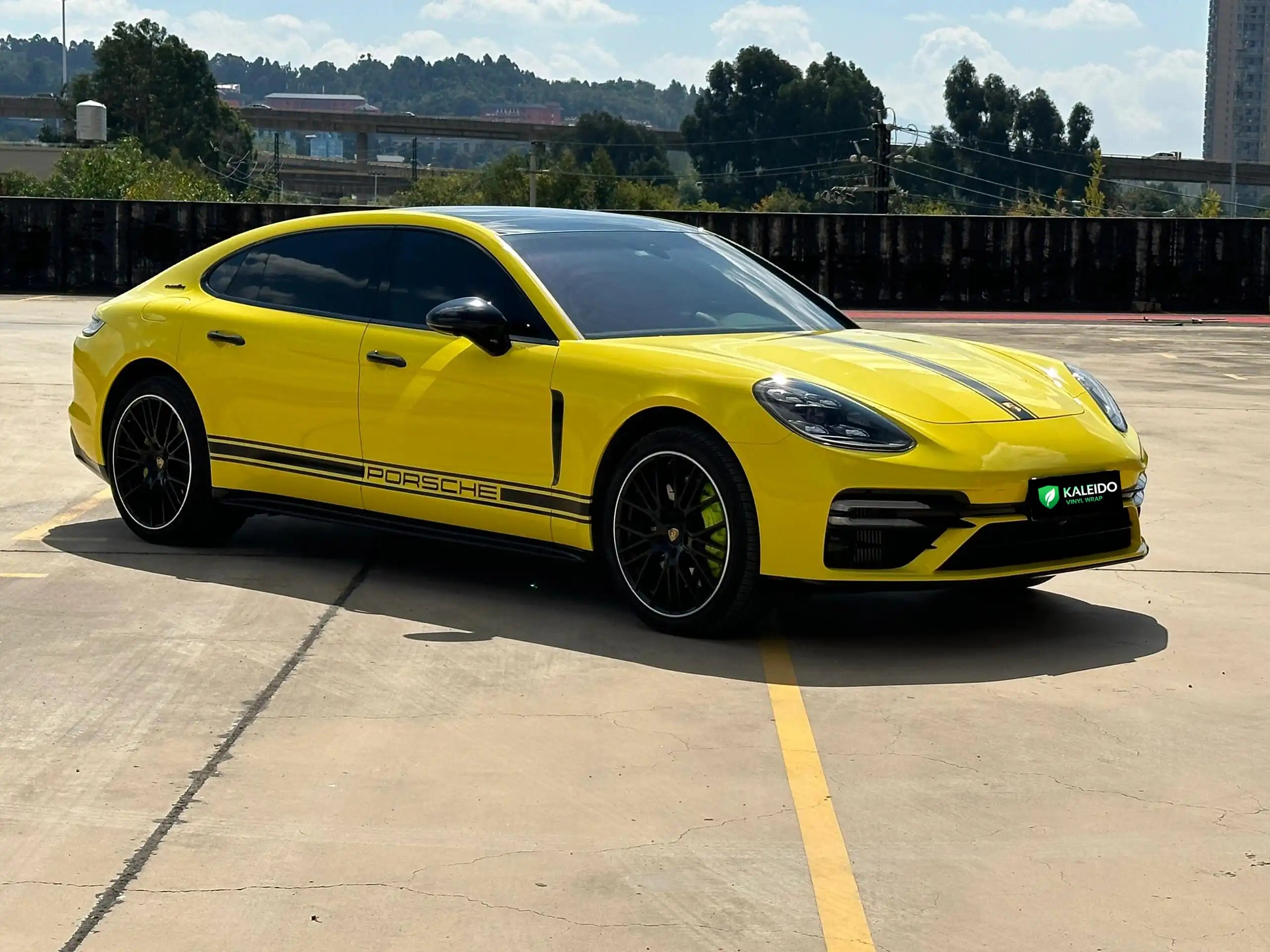 Wide front-right view of a Gloss Corn Yellow wrapped modified Porsche Panamera - Kaleido
