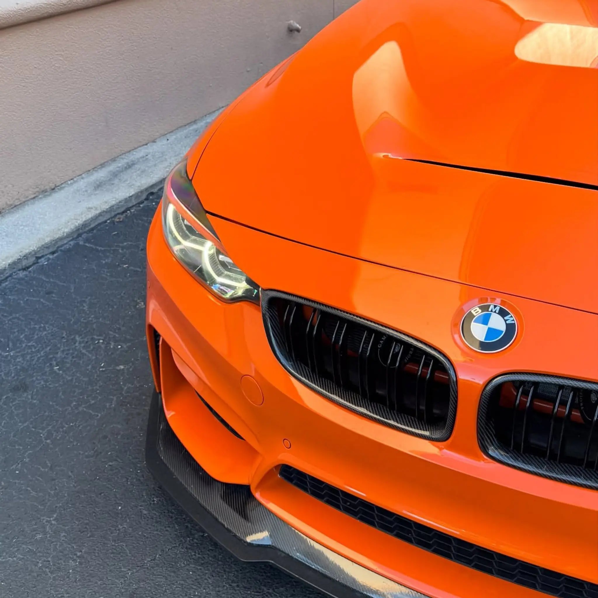 Detailed shot of Gloss Hermès Orange vinyl on a modified BMW M4 (F82) front grille - Kaleido