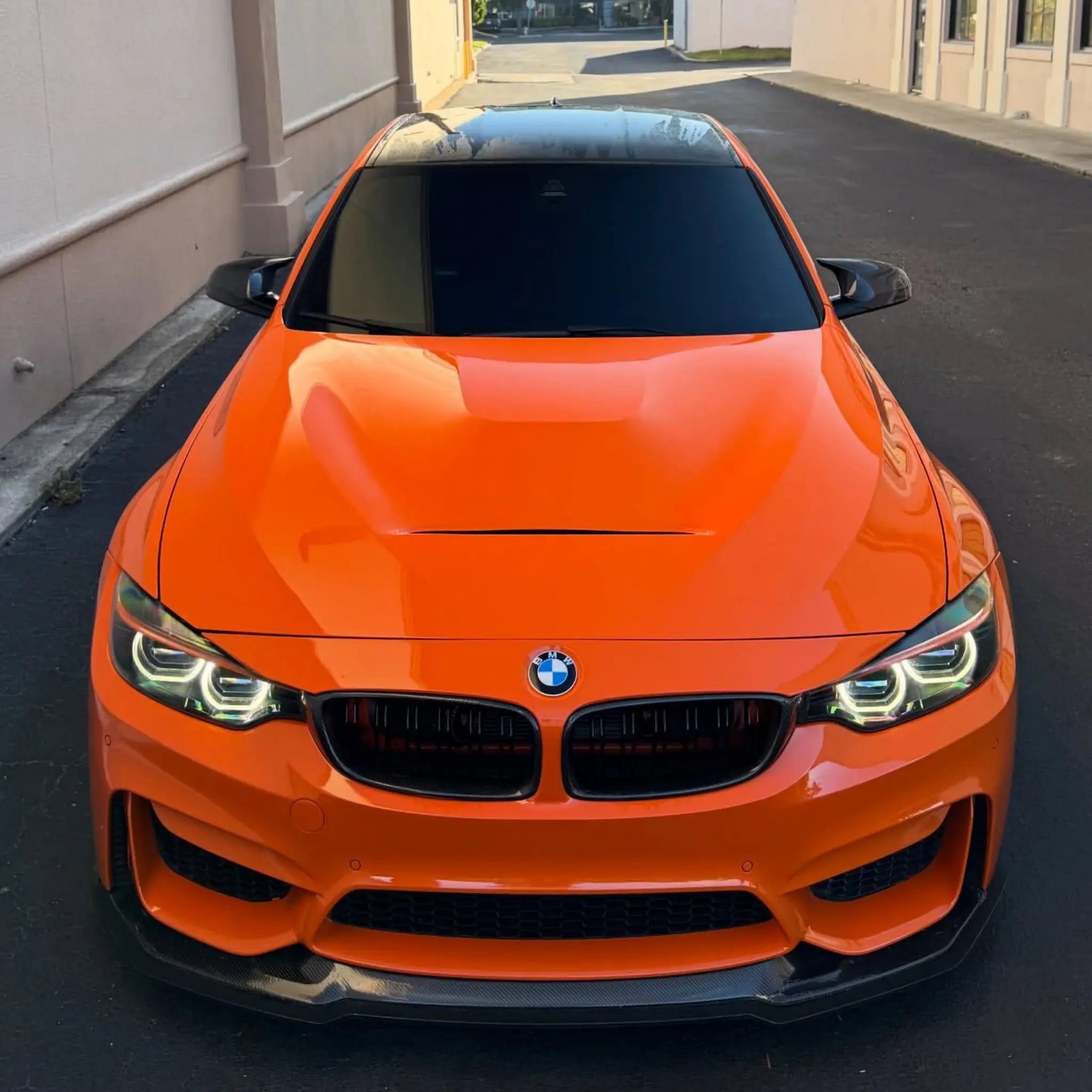Front view of a modified BMW M4 (F82) coupe in Gloss Hermès Orange wrap - Kaleido