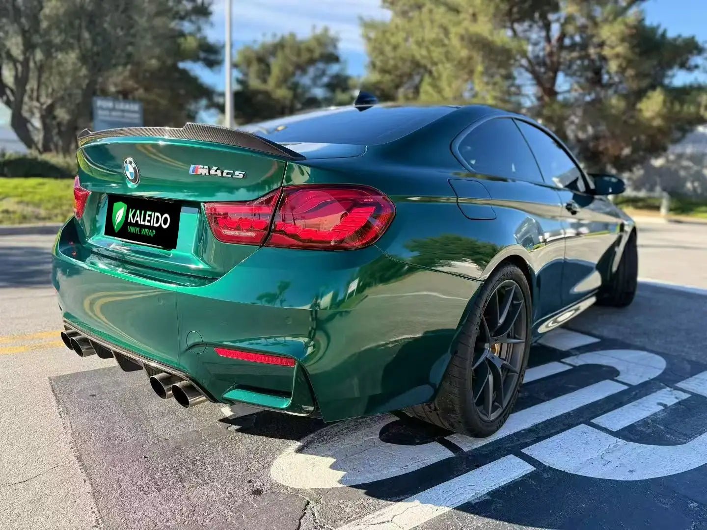 BMW M4 with Gloss Metallic Agate Green film - rear-right angle showcasing wide body - Kaleido