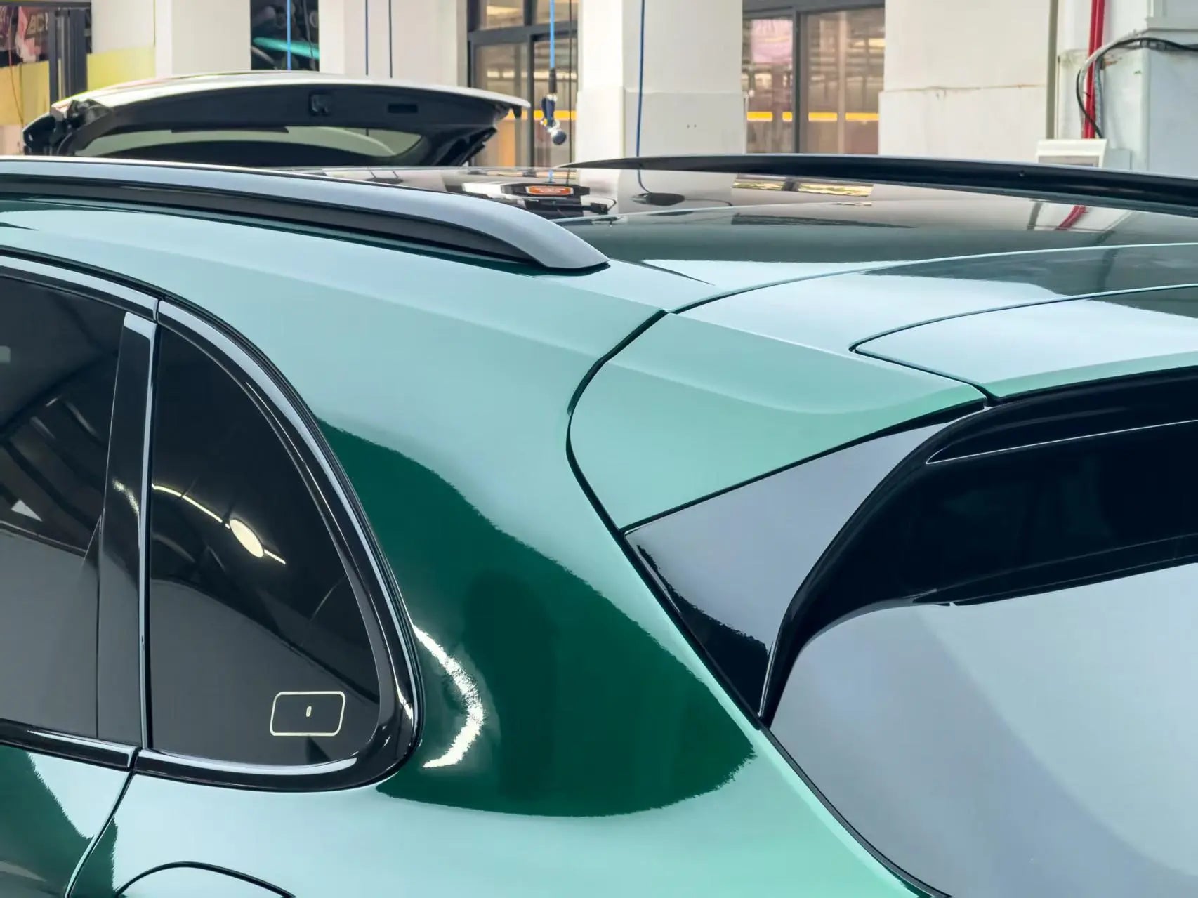 Close-up of Gloss Metallic Agate Green wrap on Porsche Cayenne C-pillar - metallic texture detail - Kaleido