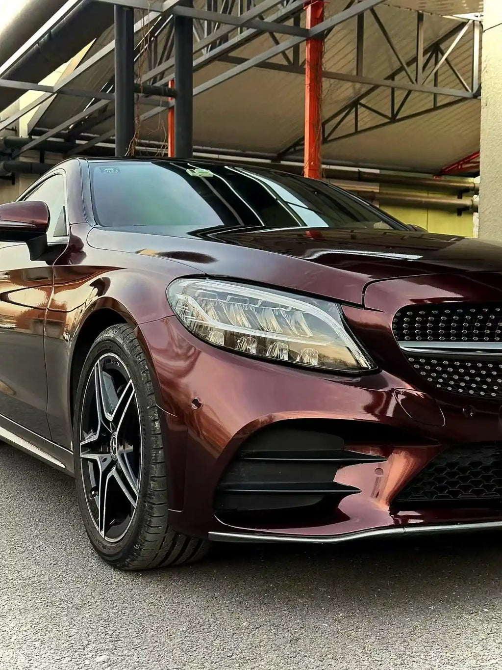 Detailed shot of Gloss Metallic Black Rose vinyl on Mercedes C-Class Coupe front-right corner - Kaleido