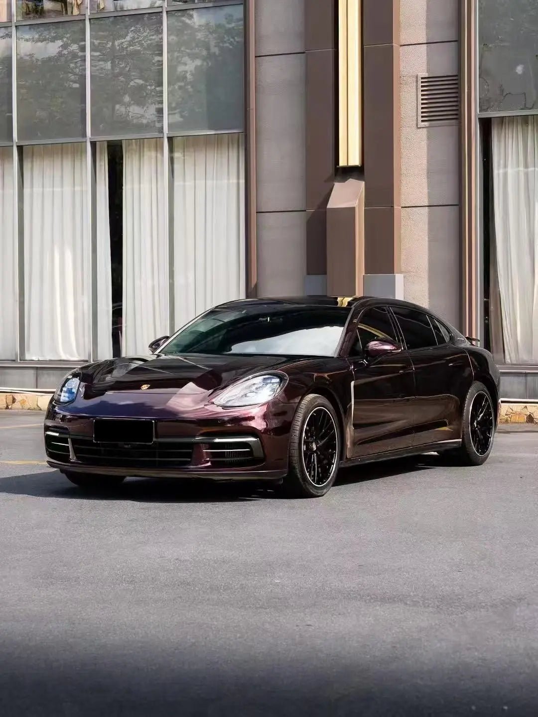 	Porsche Panamera in Gloss Metallic Black Rose wrap - wide front-left view showcasing luxury sedan - Kaleido