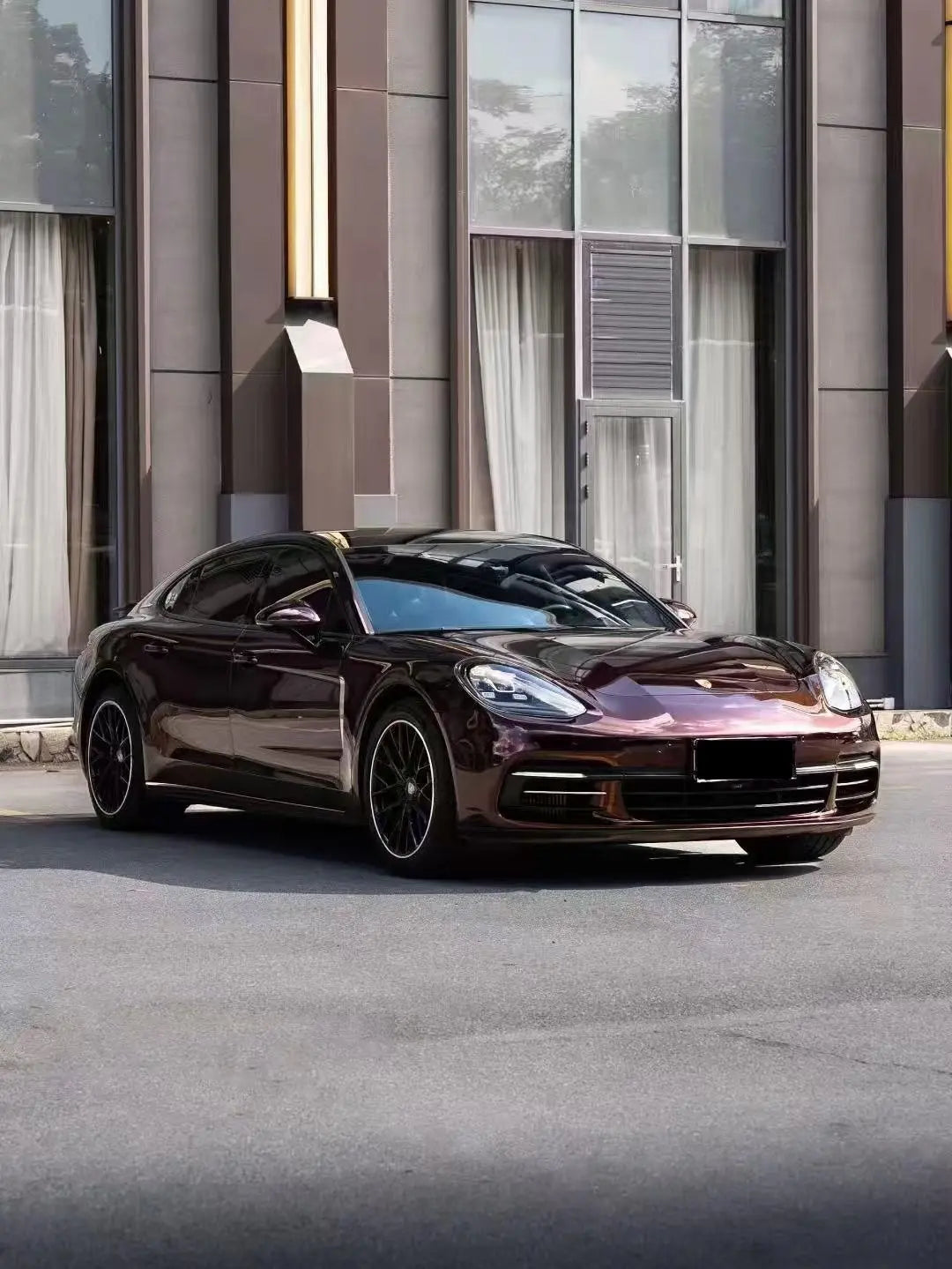 Wide front-right view of Porsche Panamera in Gloss Metallic Black Rose wrap - Kaleido