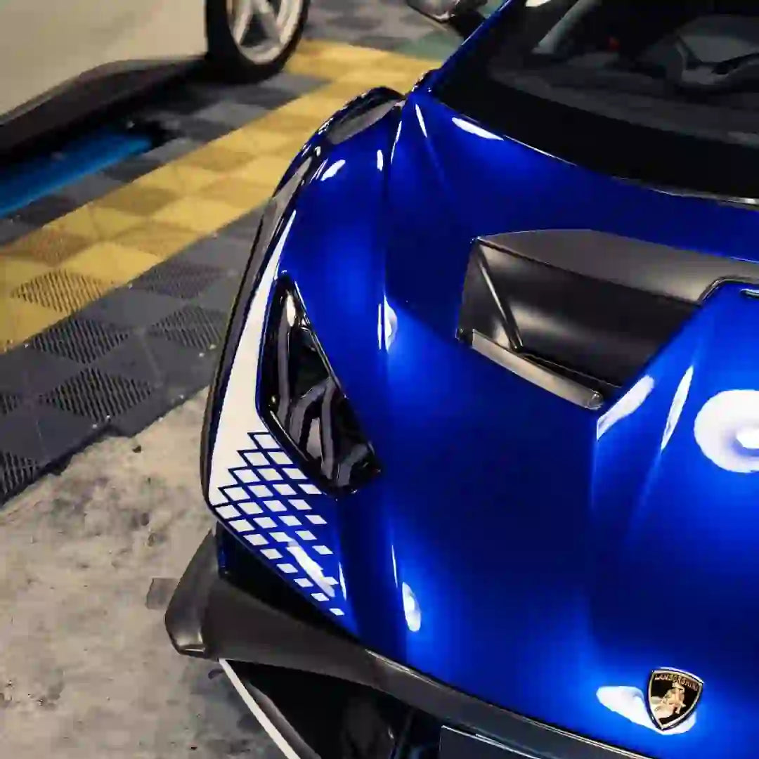 Close-up of Deep Blueberry Metallic film on Lamborghini Huracán STO front-left - showcasing headlight and air intake - Kaleido
