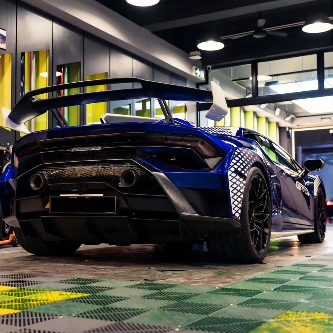 Low-angle rear shot of Deep Blueberry Metallic wrapped Huracán STO - emphasizing exhaust and wing design - Kaleido