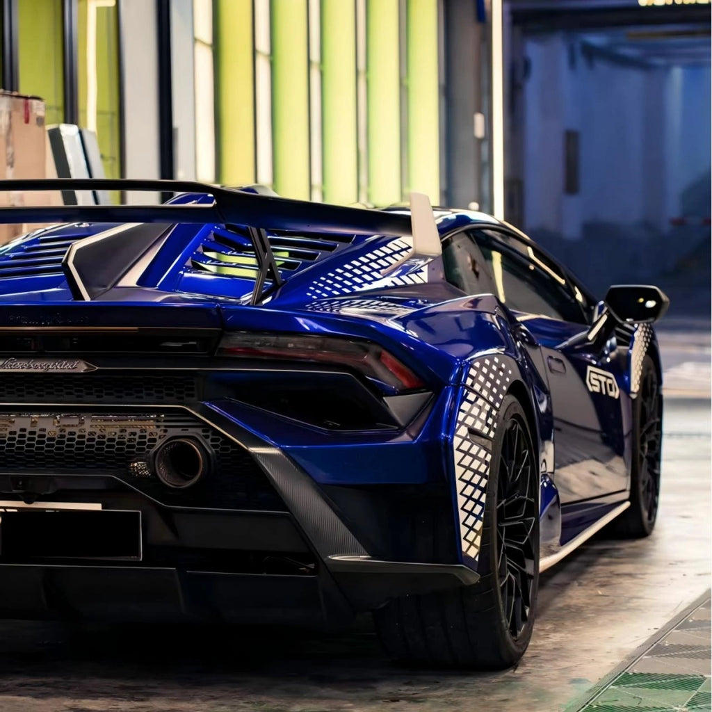 Lamborghini Huracán STO in Deep Blueberry Metallic - side-rear view featuring large wing and STO logo - Kaleido