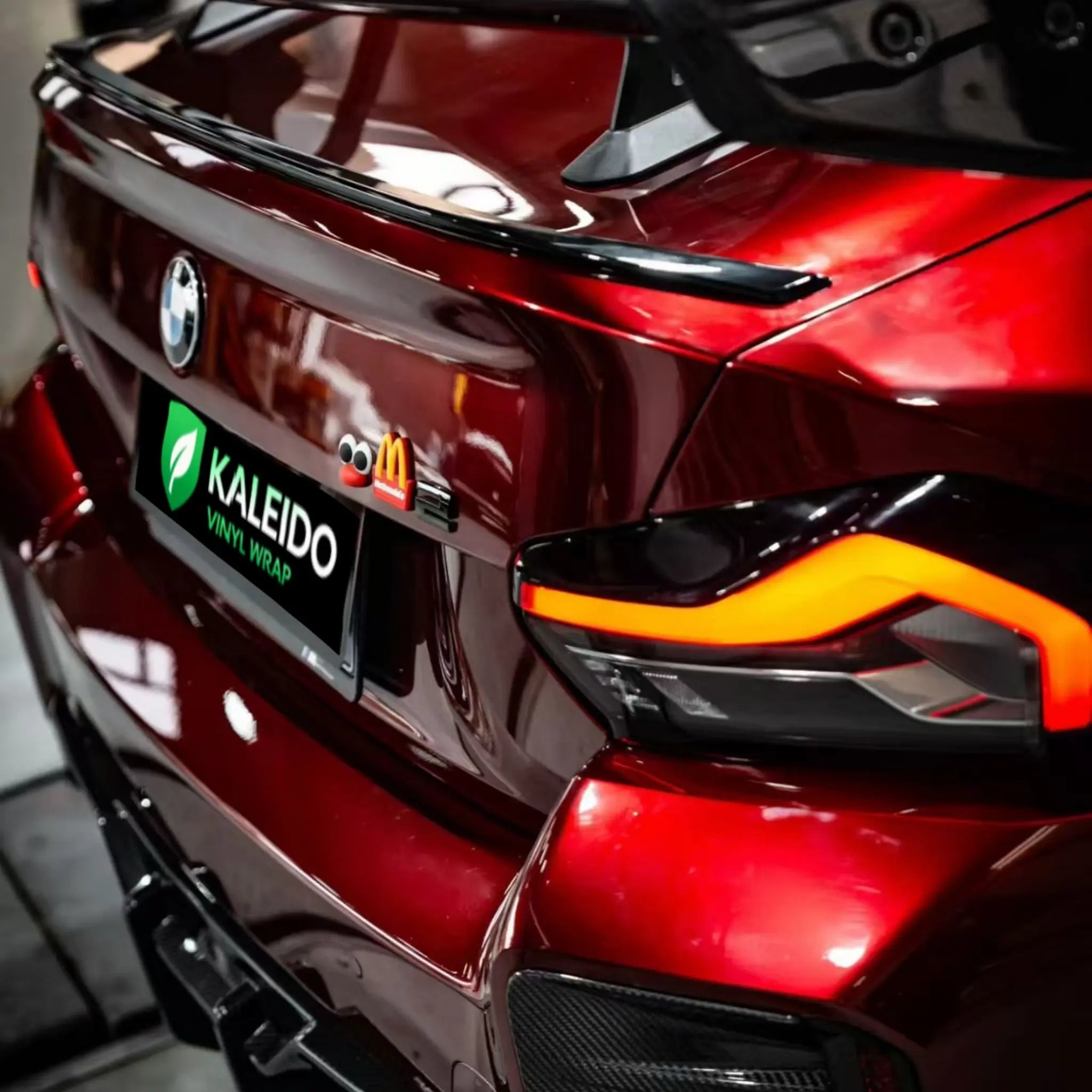 Detailed shot of Gloss Metallic Dragon Blood film on BMW M2 rear bumper - Kaleido