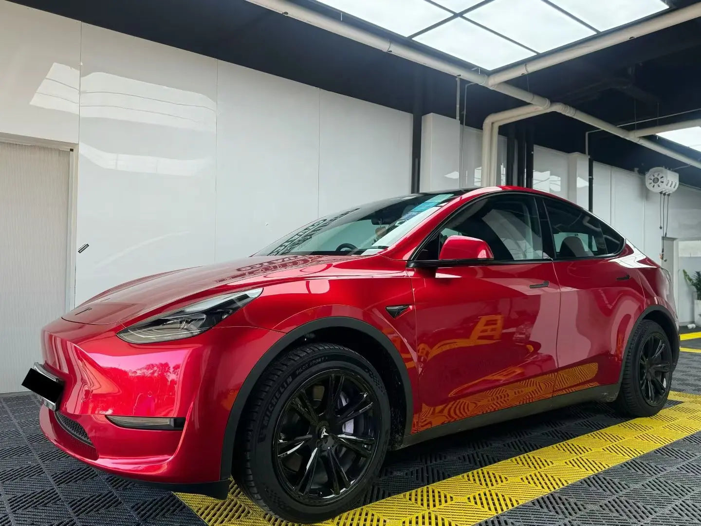 Gem Red gloss metallic vinyl on Tesla Model Y front-left - elegant color presentation - Kaleido
