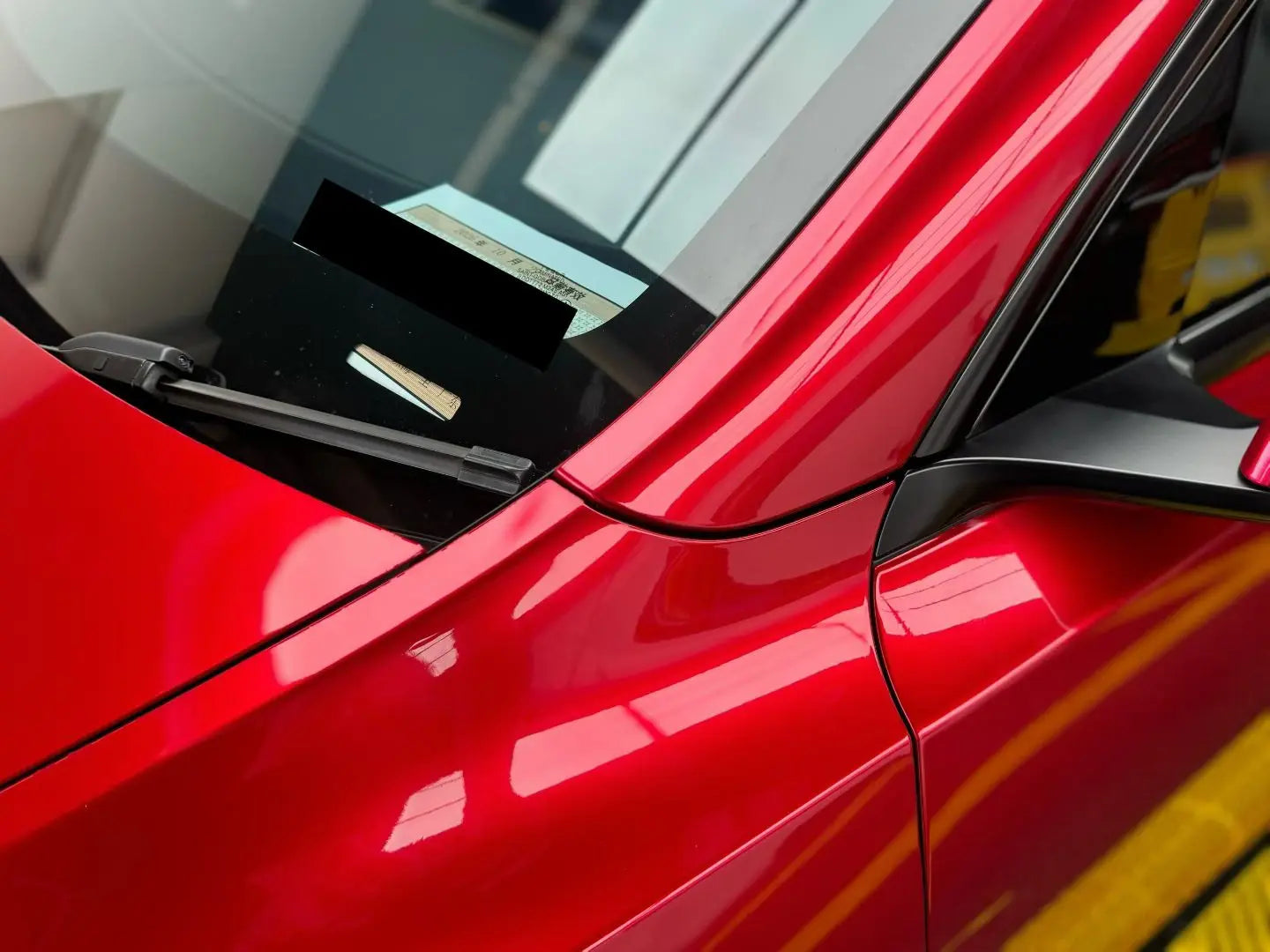 Close-up of Gem Red metallic film on Tesla Model Y left front fender - crystal-like sparkle effect - Kaleido