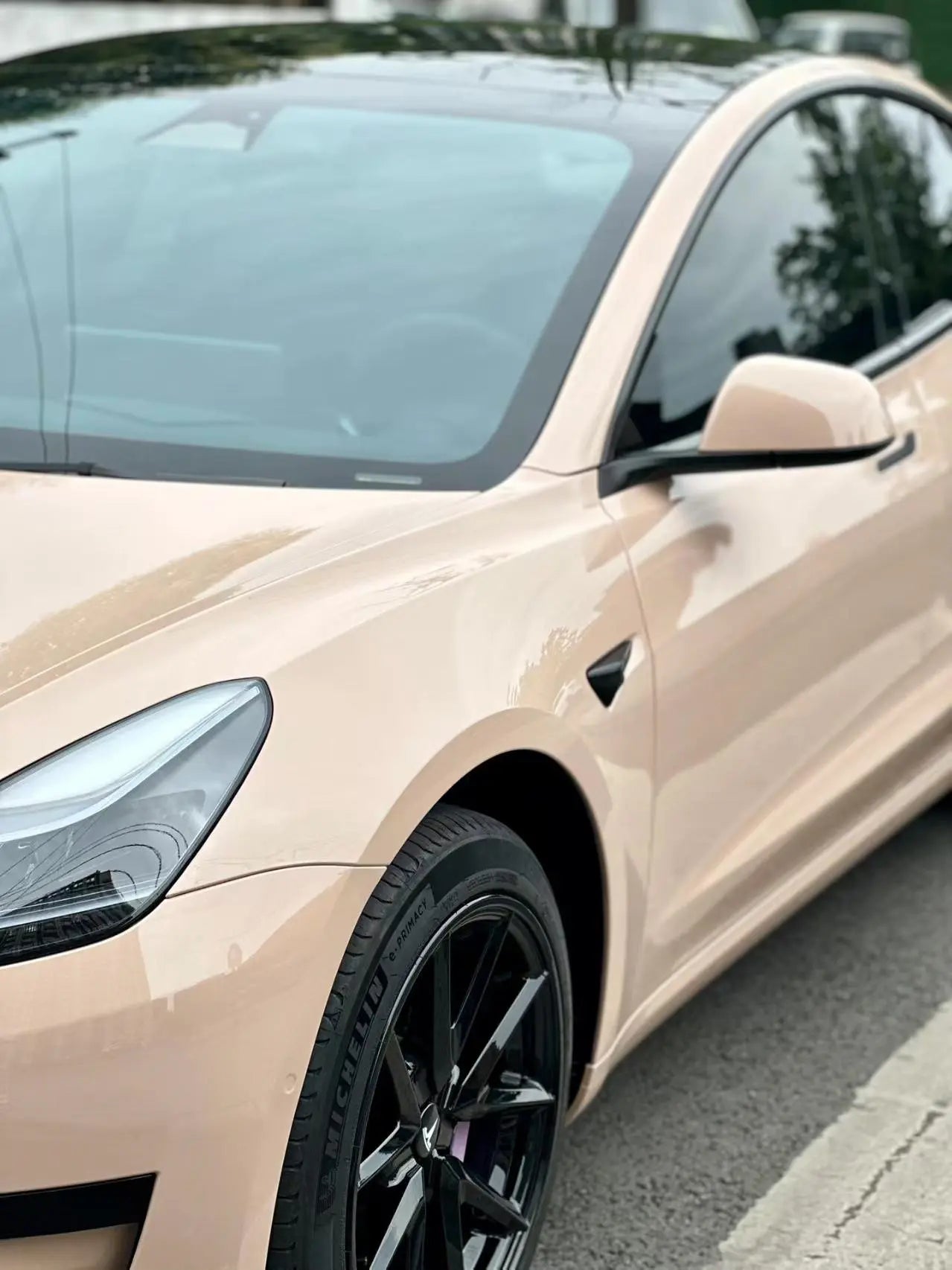 Close-up front-left of Tesla Model 3 in Gloss Milktea creamy beige wrap - Kaleido