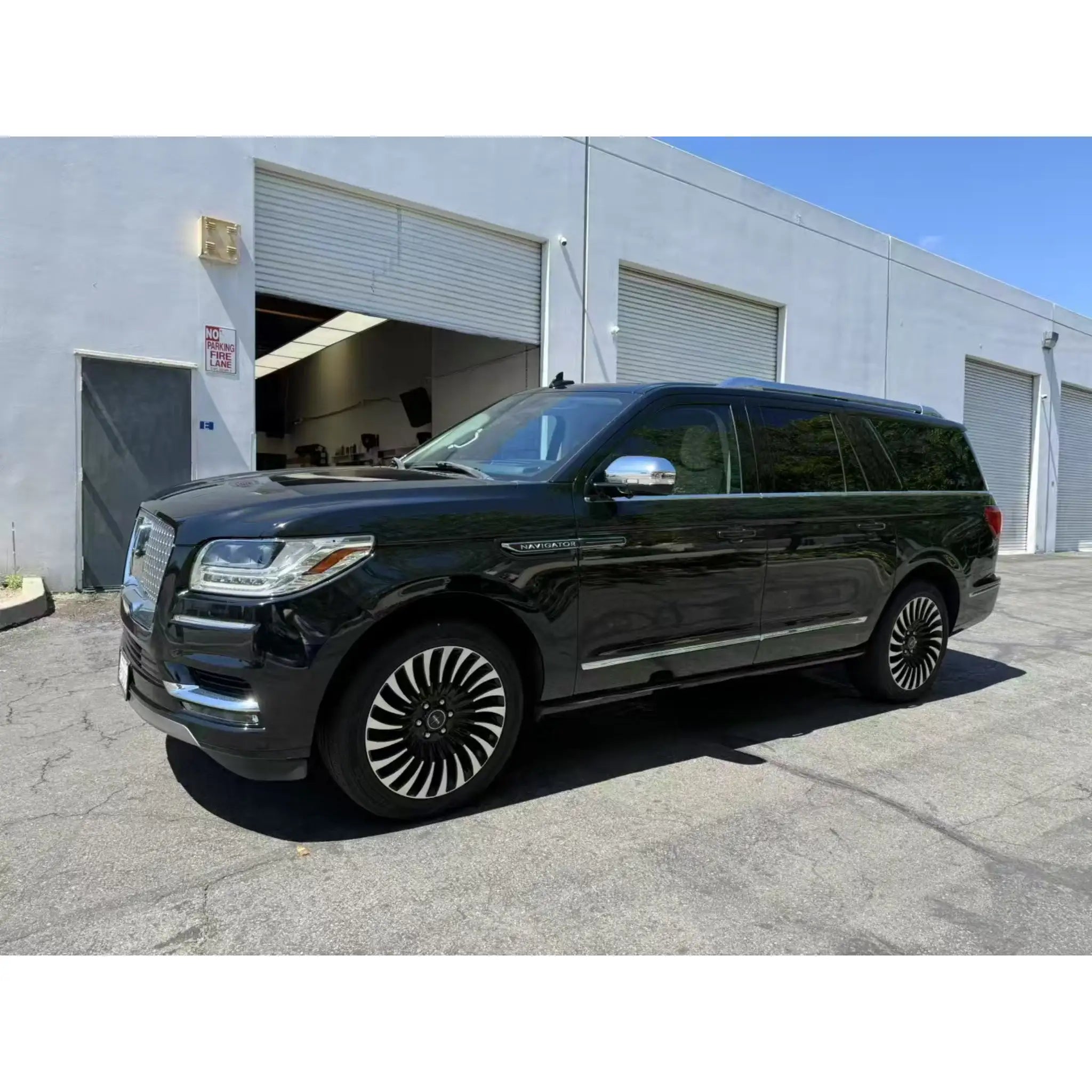Lifestyle shot of a Gloss Piano Black wrapped Lincoln Navigator in an urban setting - Kaleido
