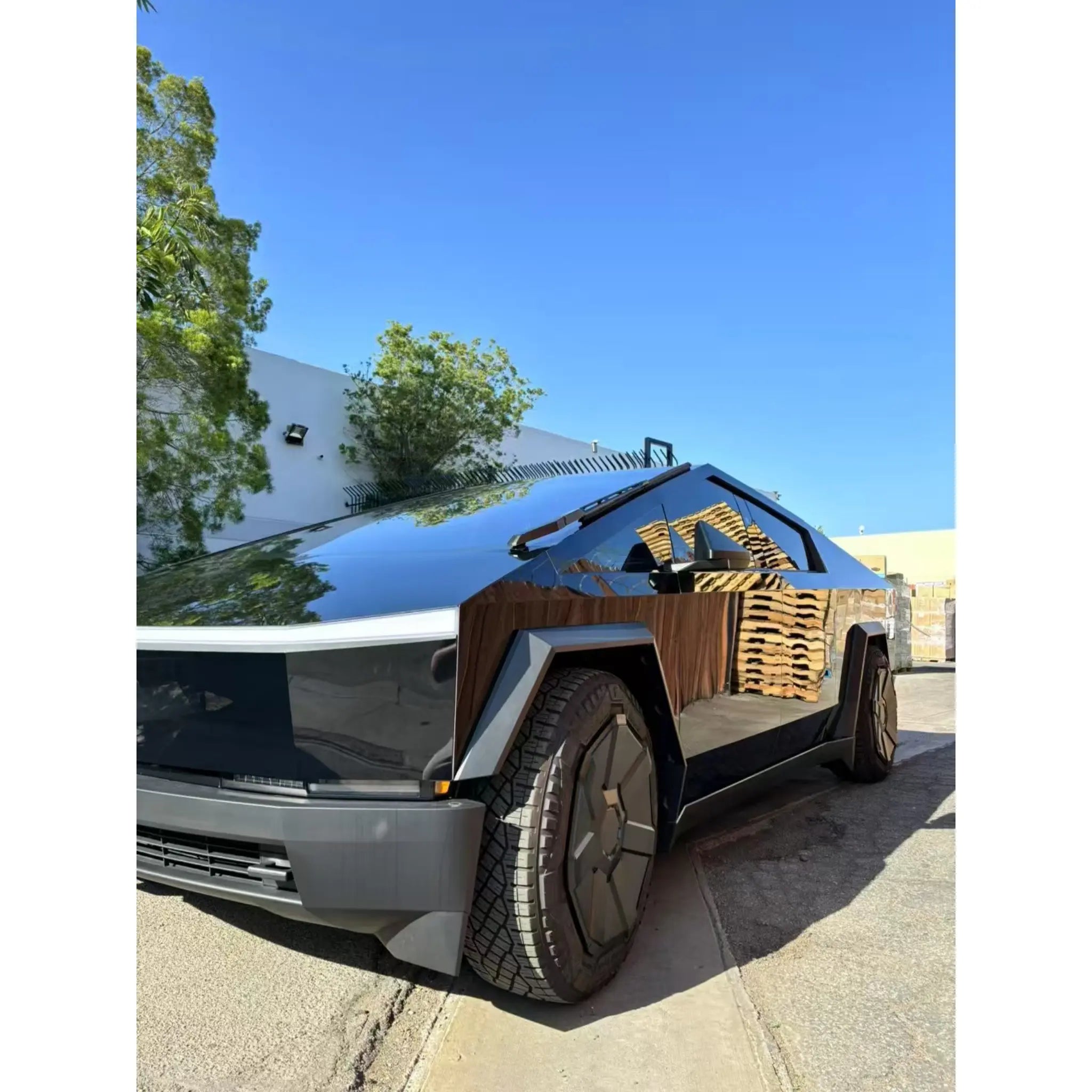 Gloss Piano Black vinyl wrap on the front-left angle of a Tesla Cybertruck - Kaleido