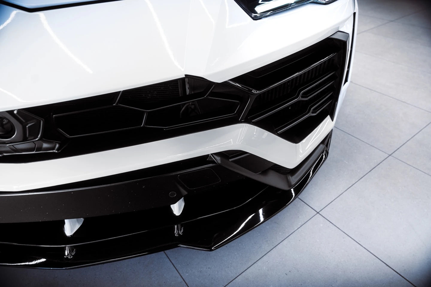 Detailed shot of Gloss Piano White vinyl on the Lamborghini Urus front-left headlight area - Kaleido