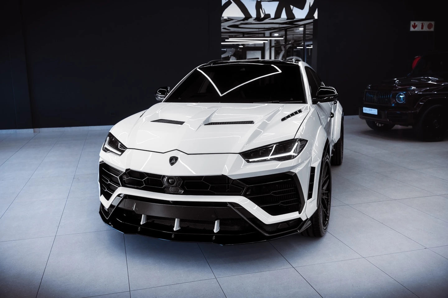 High-angle front-left view of a Lamborghini Urus in Gloss Piano White wrap - Kaleido
