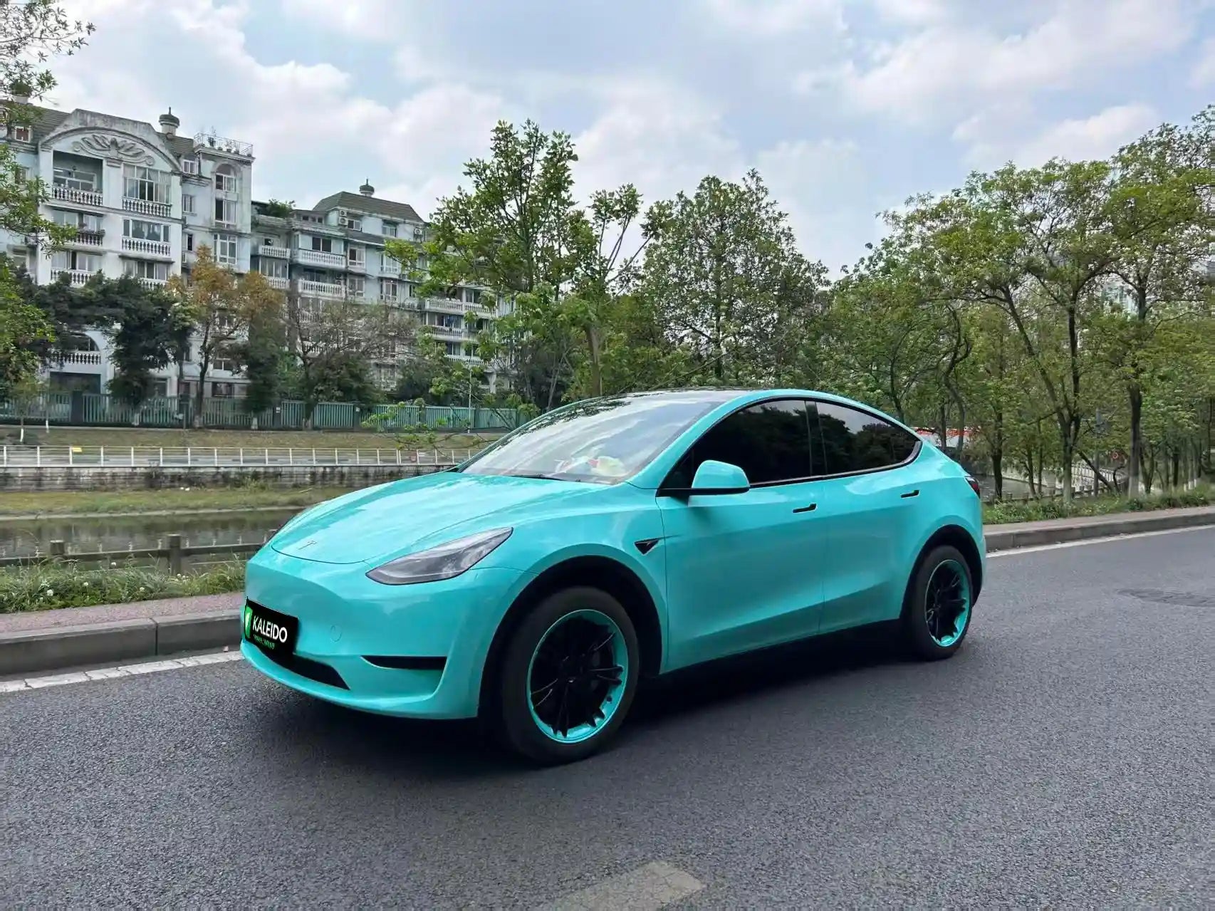 Tesla Model Y in Gloss Tiffany vinyl wrap - front-left angle with iconic blue-green color - Kaleido