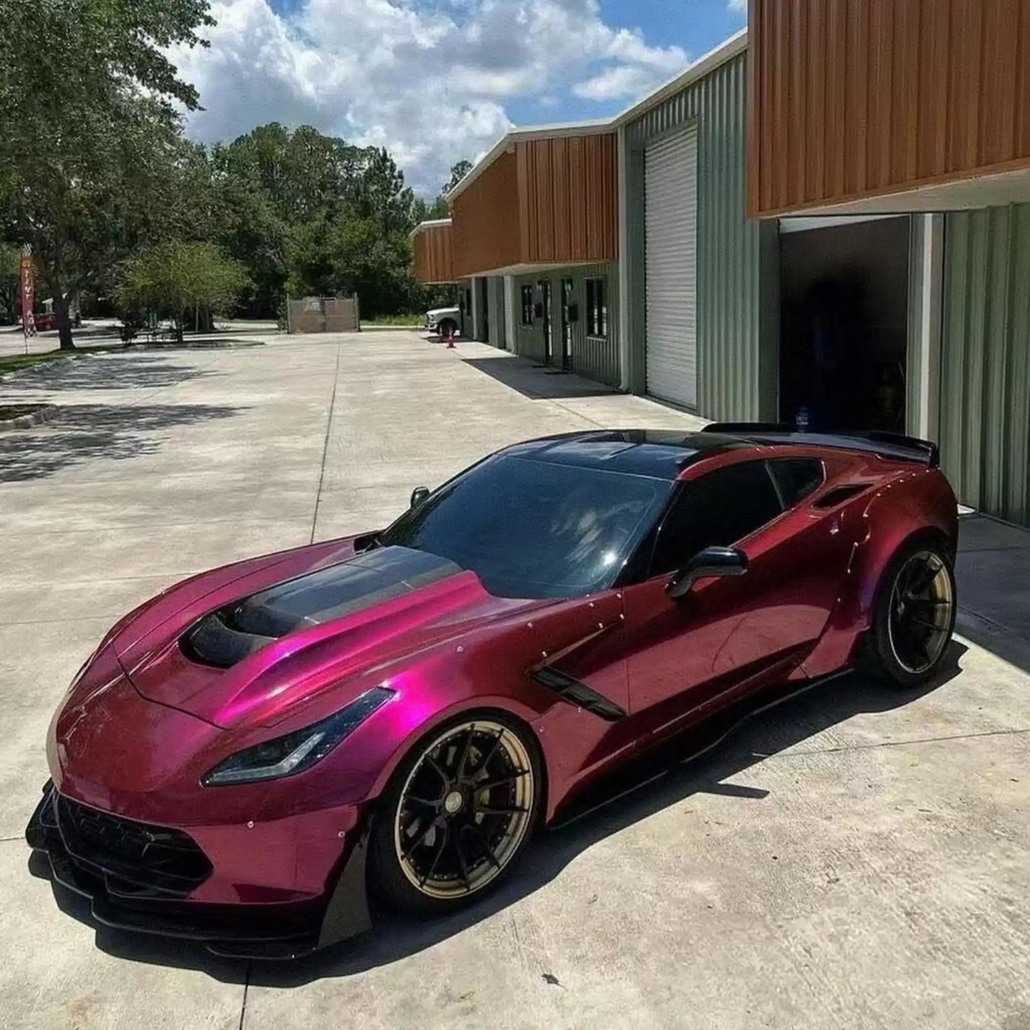Glossy Metallic Rubellite Purple wrap on a widebody Chevrolet Corvette C7 - front-left angle - Kaleido